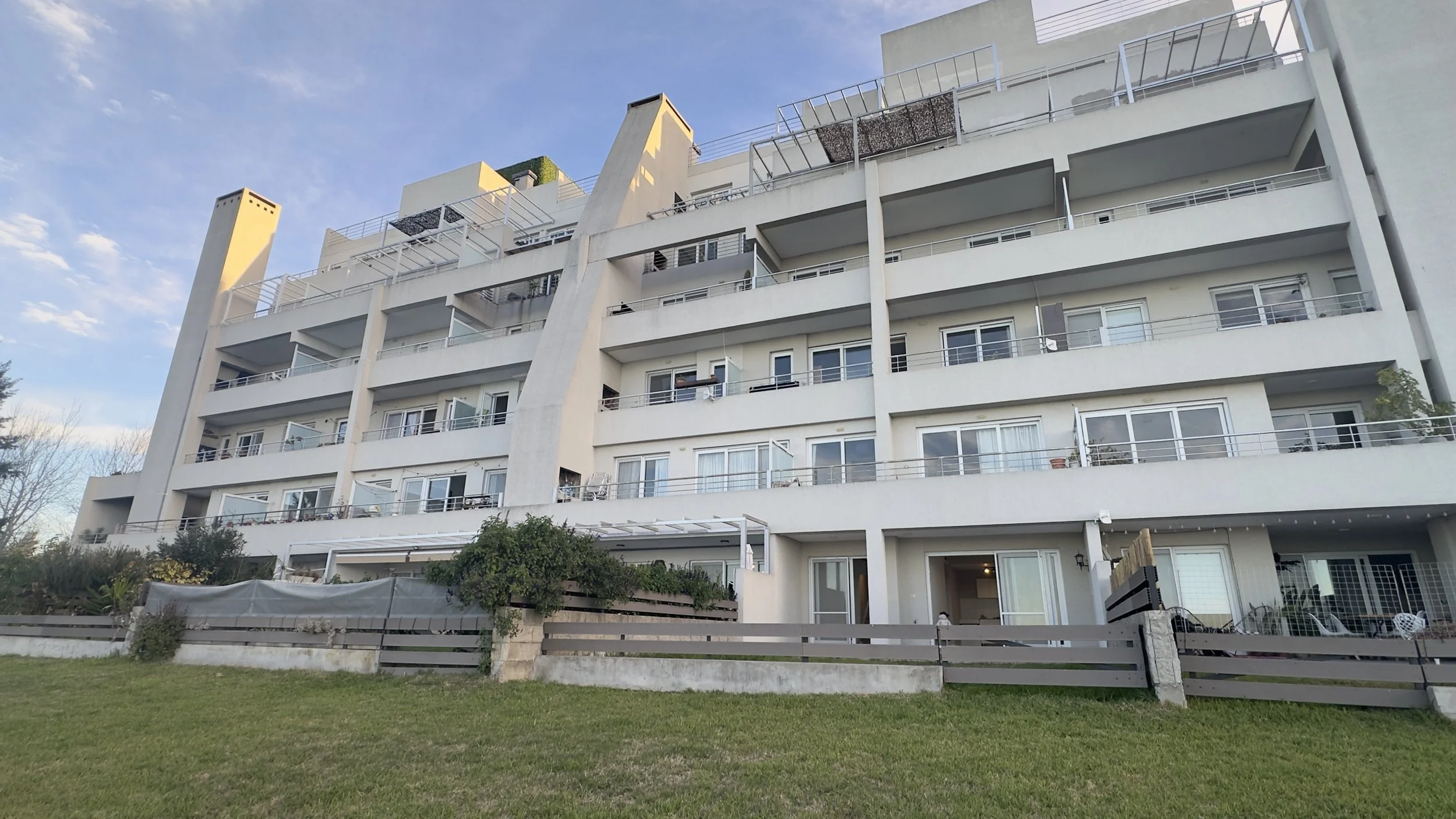 Edificio con jardín y costa al lago Vista desde Vila Vela hacia la laguna cristalina de Villanueva.