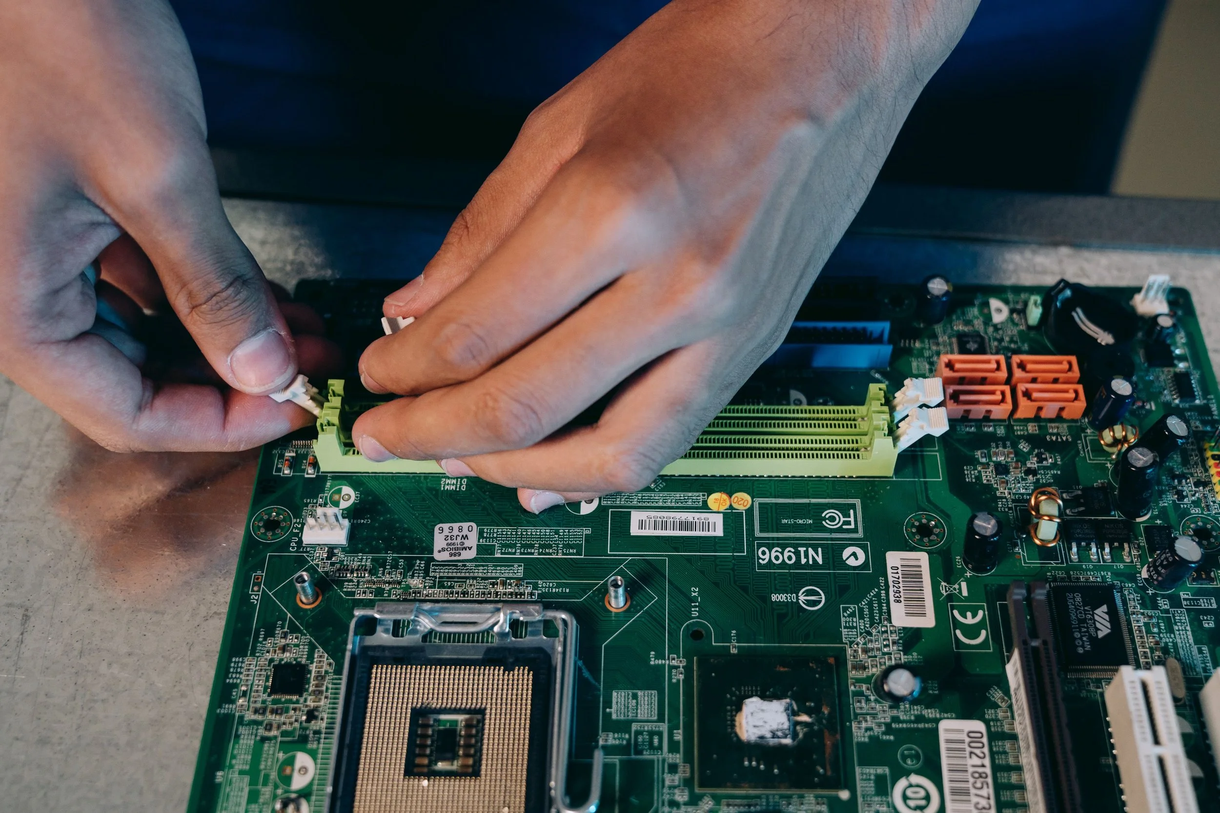 Person installing a memory module into a computer motherboard.
