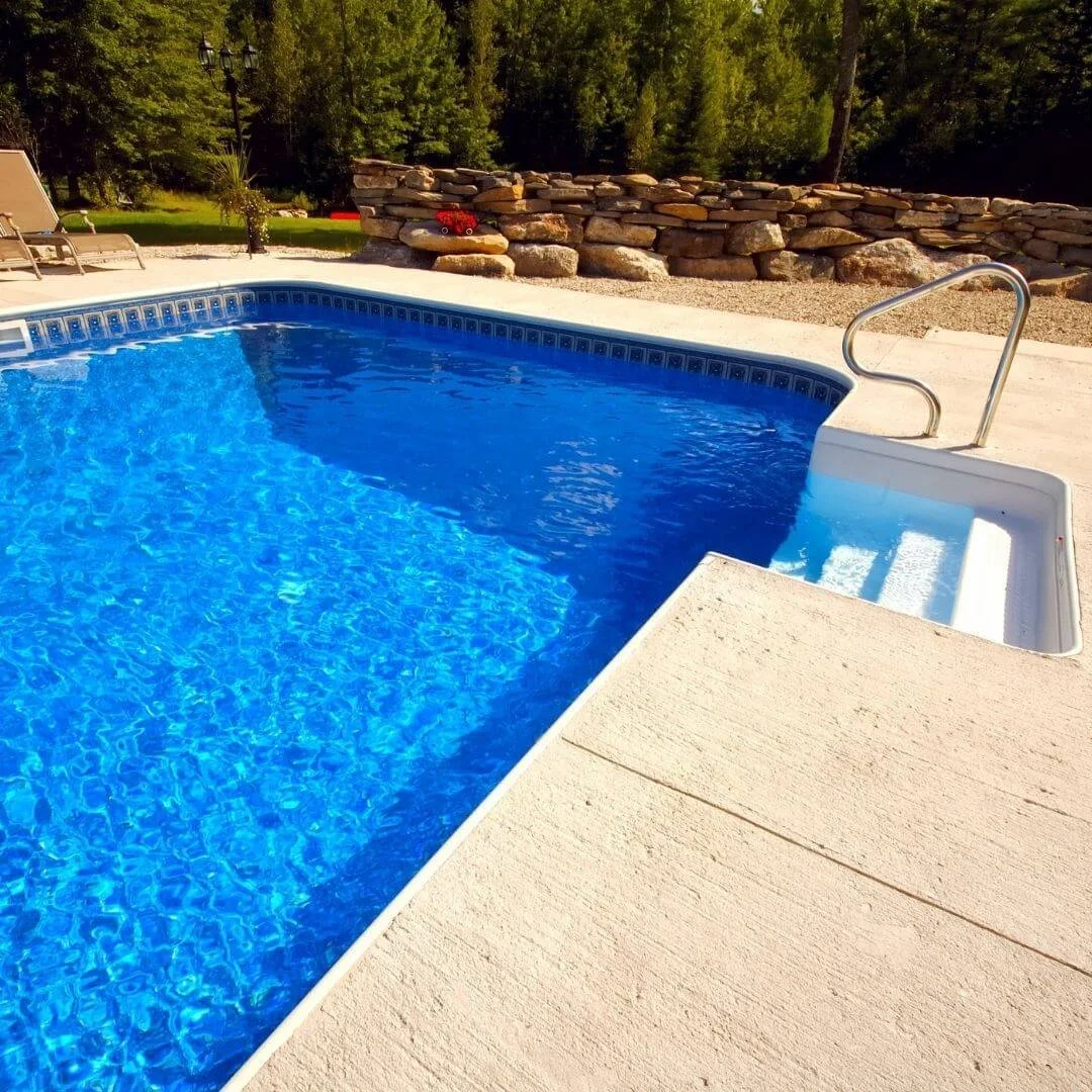 a beautiful pool with a new concrete pool deck around it