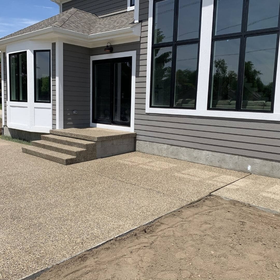 a backyard with exposed aggregate concrete