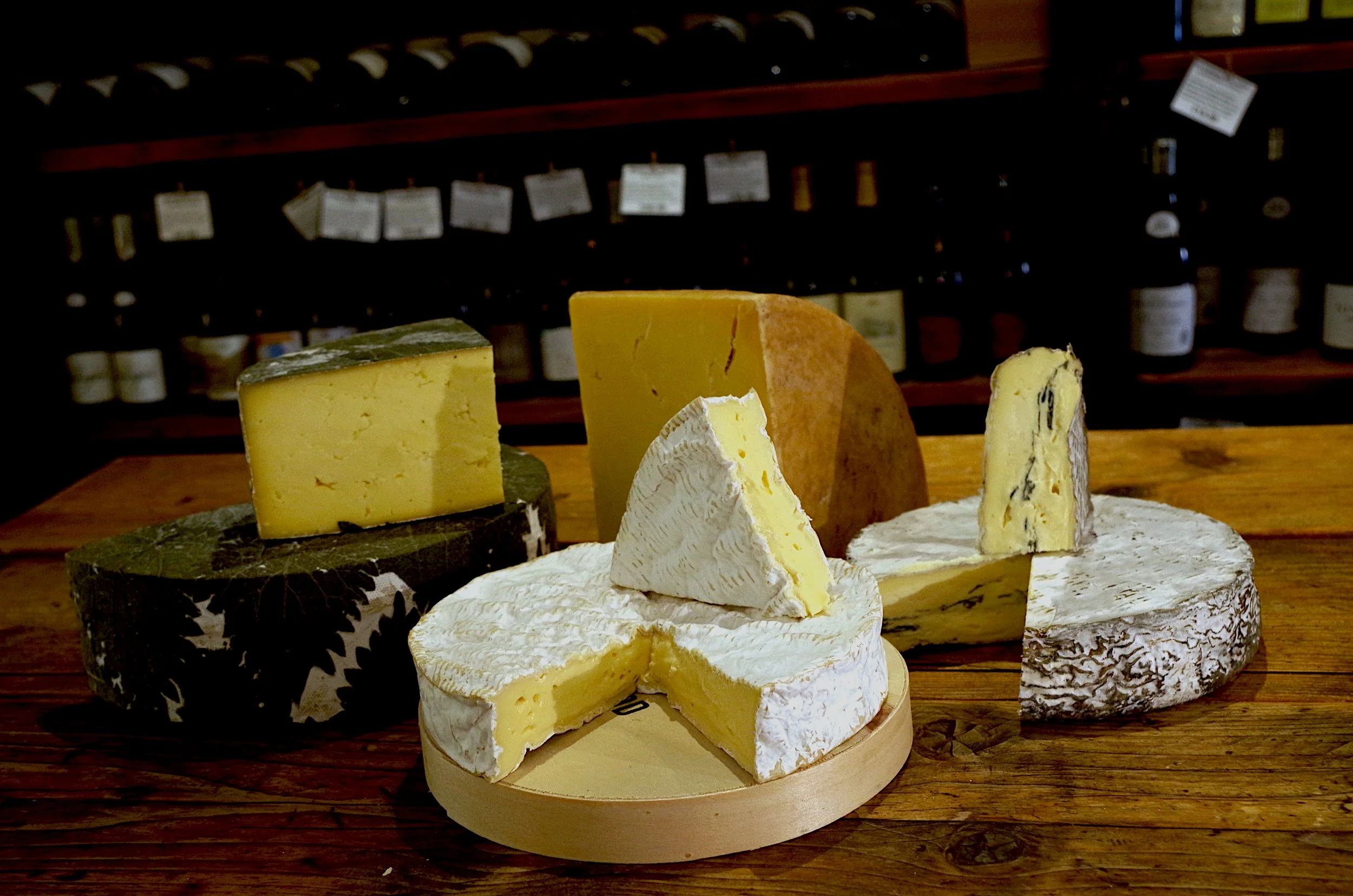 image of a selection of cheeses arranged on a wooden table