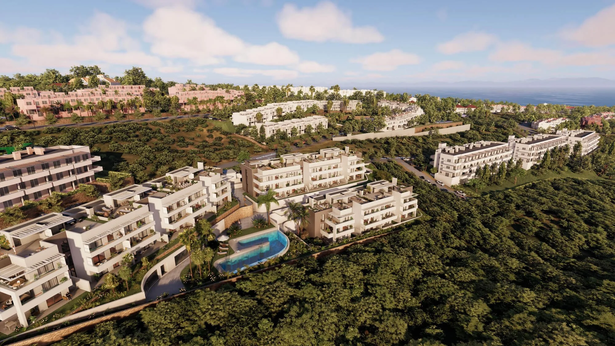 Aerial view of a modern residential area with white apartment buildings, lush green trees, a swimming pool, and overlooking the ocean in the distance.