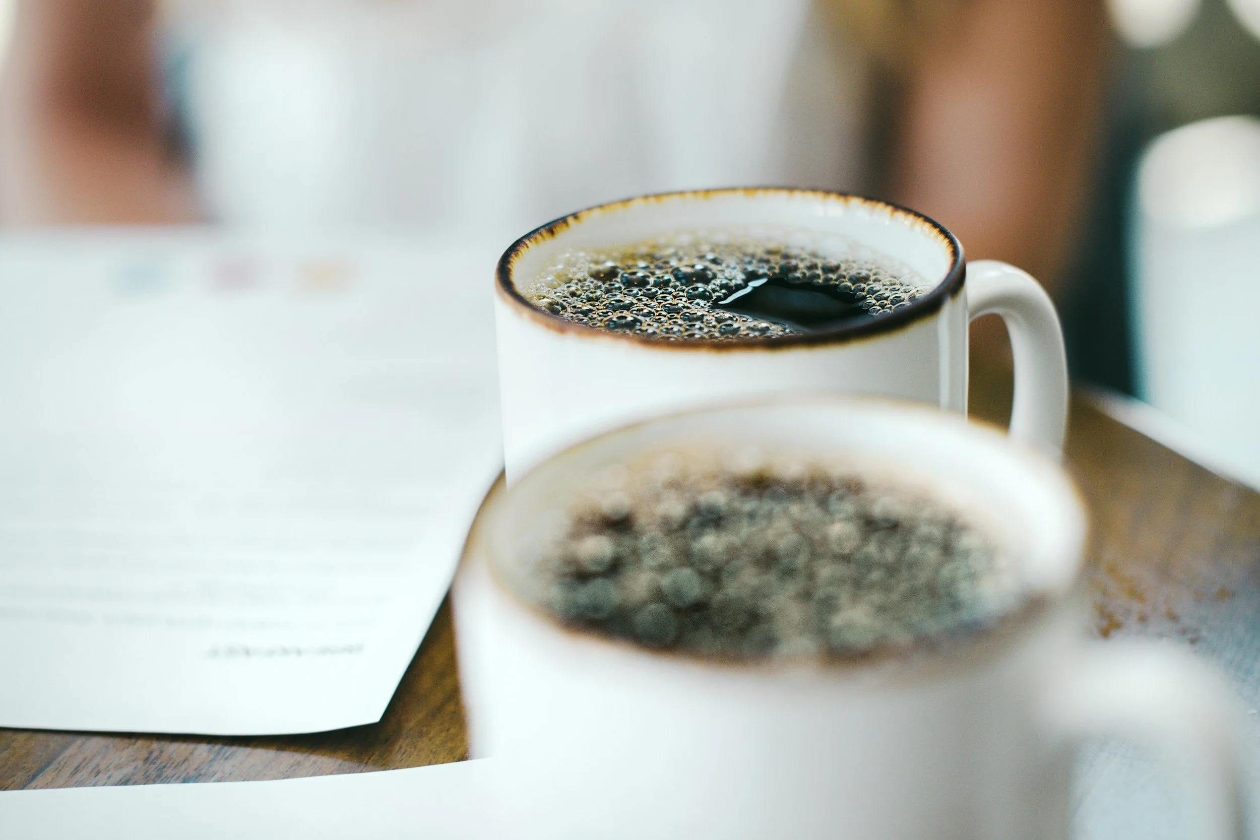wo coffee cups and notes on a table during a conversation