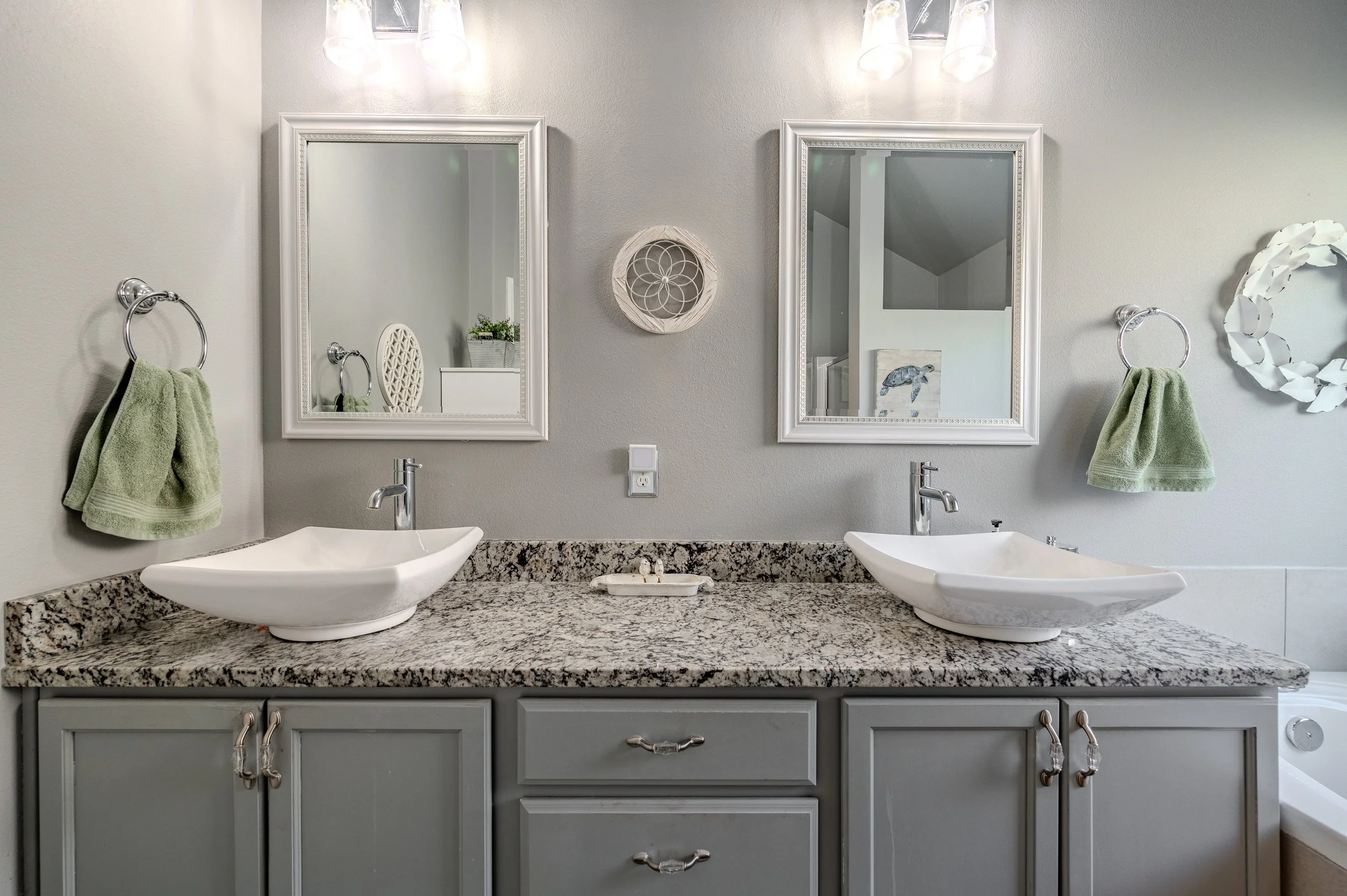 Professional HDR real estate photograph of a modern bathroom with double vanity and granite countertops.