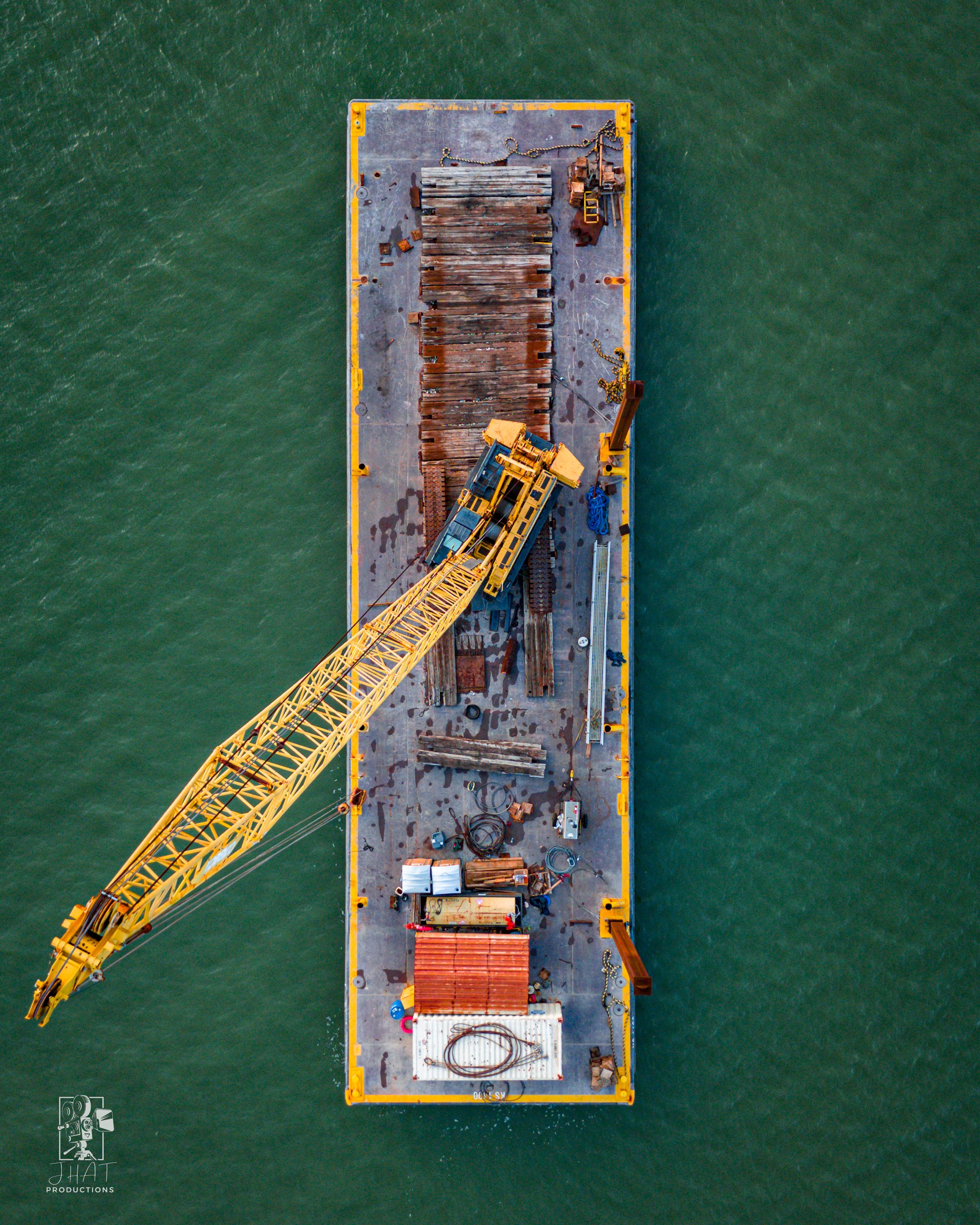 Top-down drone photo of a crane barge removing sections of the old Harbor Bridge in Corpus Christi.