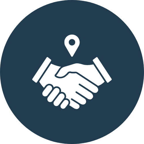 Icon of two hands shaking with location marker above them, representing partnership or agreement.