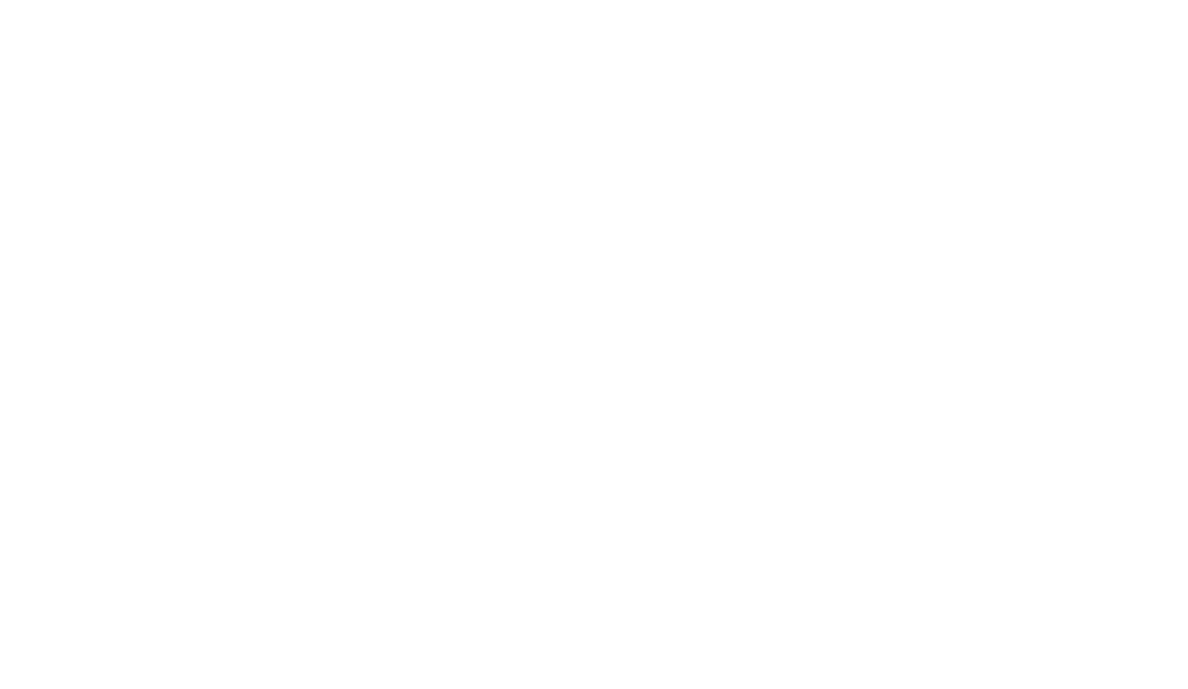 An image of a black silhouette of a person and a dog playing on the beach with a white surfboard.