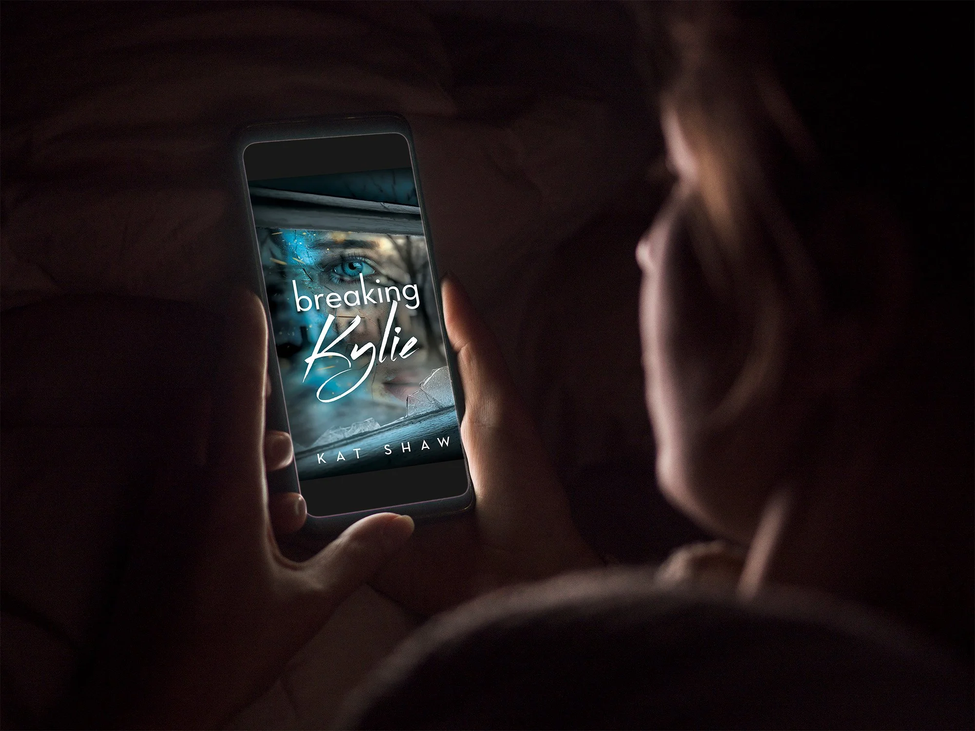 Reader holding a smartphone displaying the Breaking Kylie ebook cover by Kat Shaw