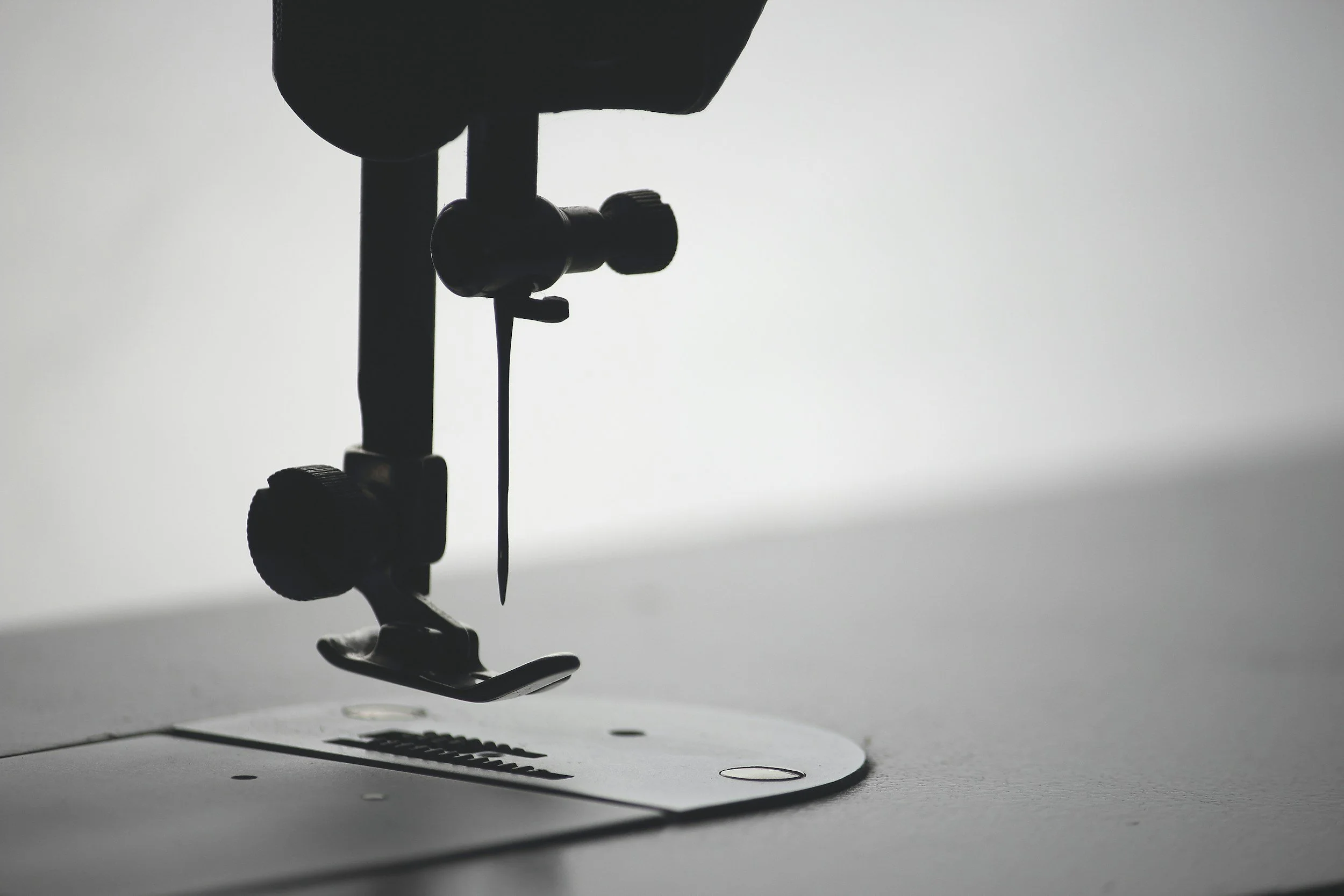 Silhouette of a sewing machine on a white surface