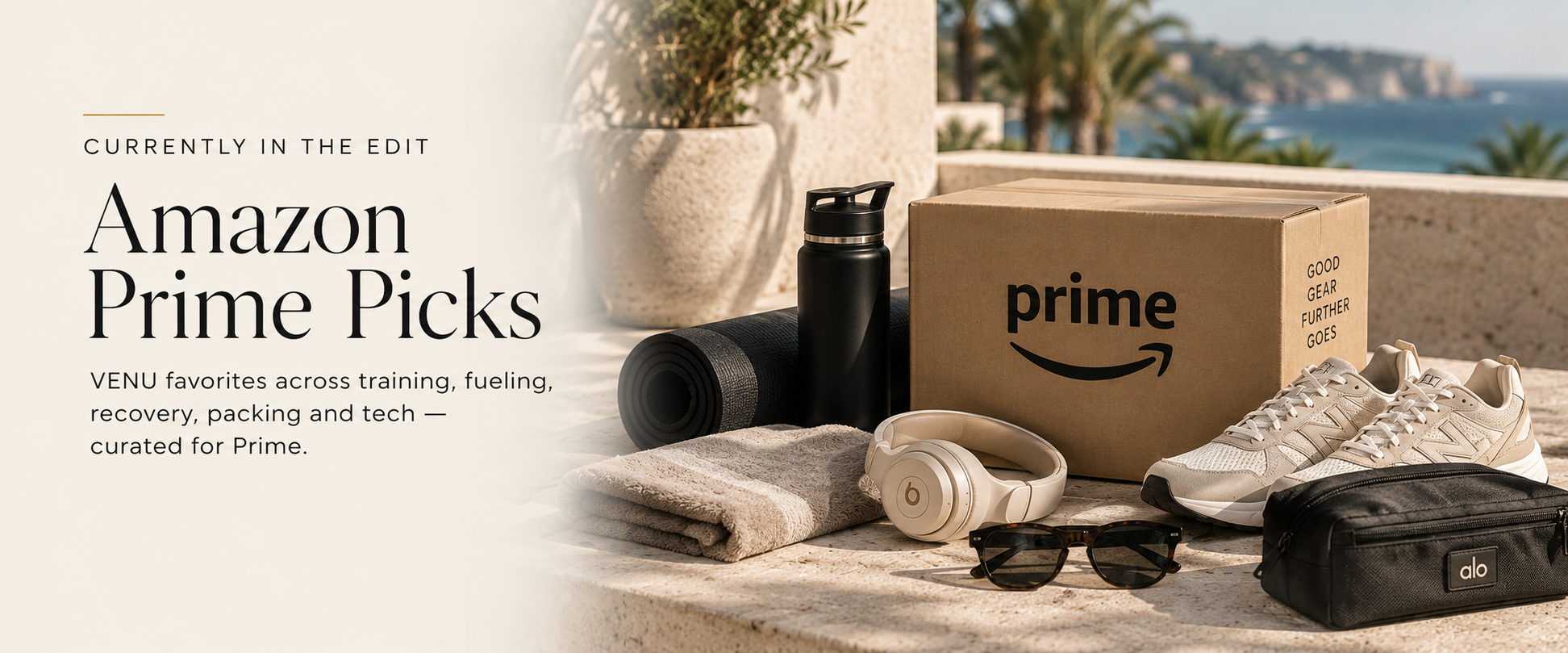 Amazon Prime Picks promotional image showing a cardboard Prime box, athletic shoes, a water bottle, sunglasses, headphones, a yoga mat, a towel, and a black carrying case on a stone surface overlooking the ocean.