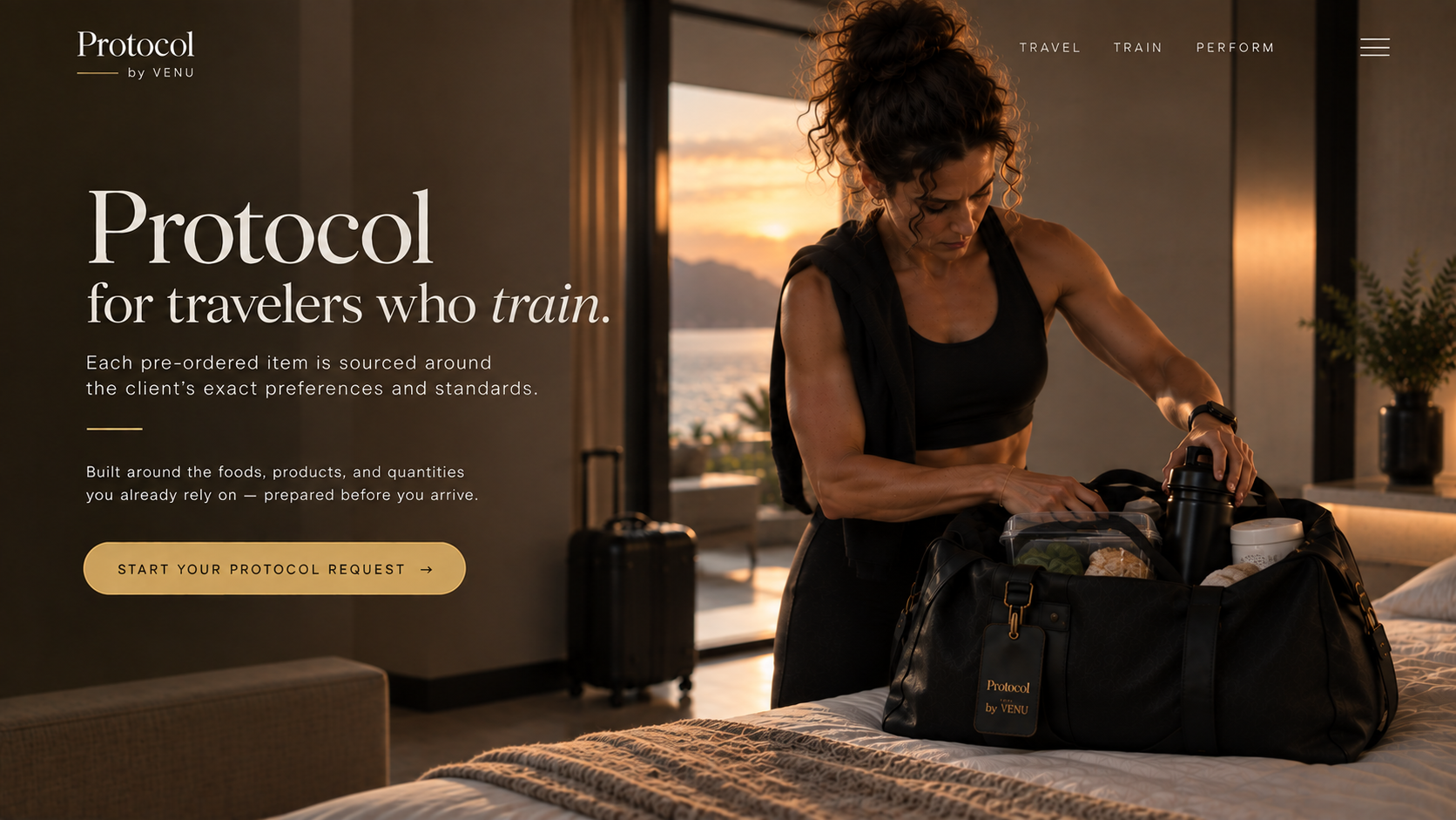Woman in workout clothes packing a black duffel bag with food and drinks in a hotel room with a scenic view of the sunset over water in the background.
