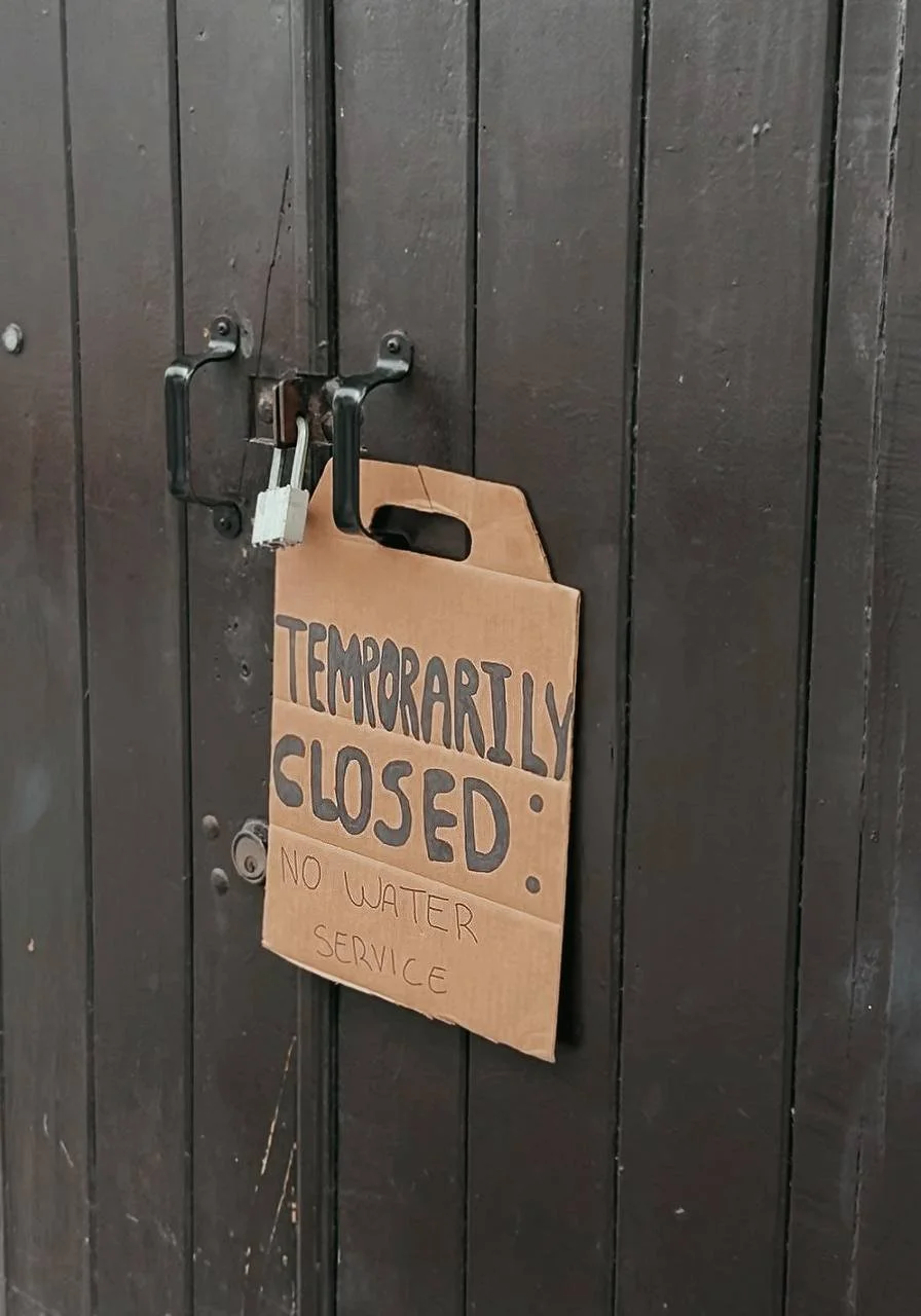 alt="Temporarily closed sign on a business in San Juan, Puerto Rico due to no water service during the ongoing water crisis"
