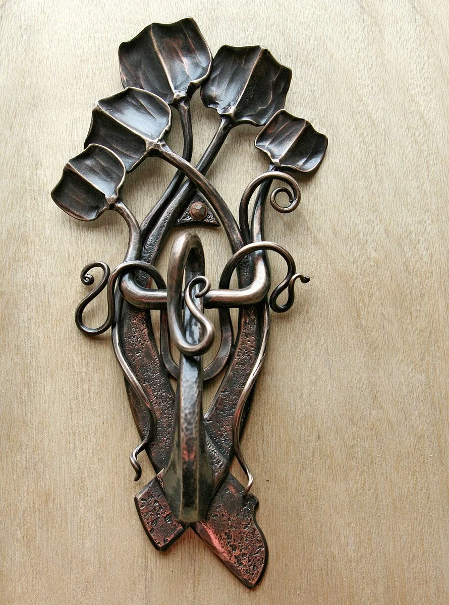 This artisan hand-forged bronze door knocker features an intricate leaf and vine motif with hammered textural detailing, adding organic, nature-inspired elegance to any entryway. A functional work of fine art, this custom bronze knocker showcases the