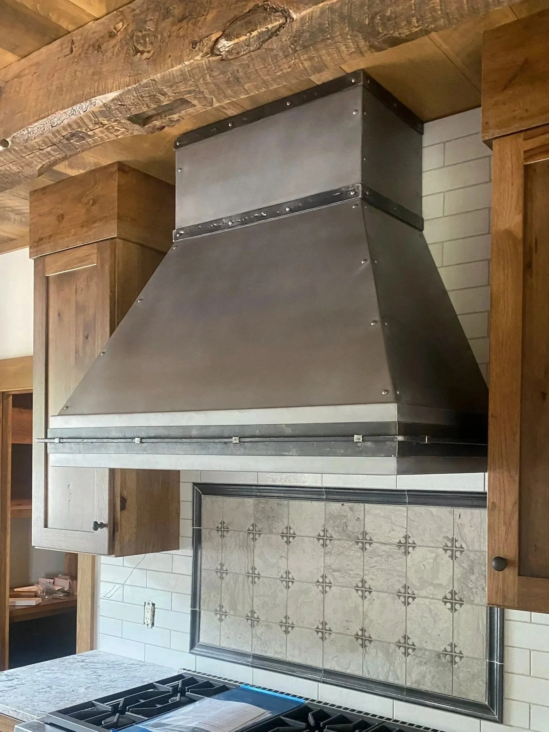Pewter Gray Custom Range Hood – This handcrafted pewter gray range hood showcases clean architectural lines and a durable artisan finish, making it the perfect centerpiece for modern rustic, mountain, and transitional kitchens. Built to your exact sp