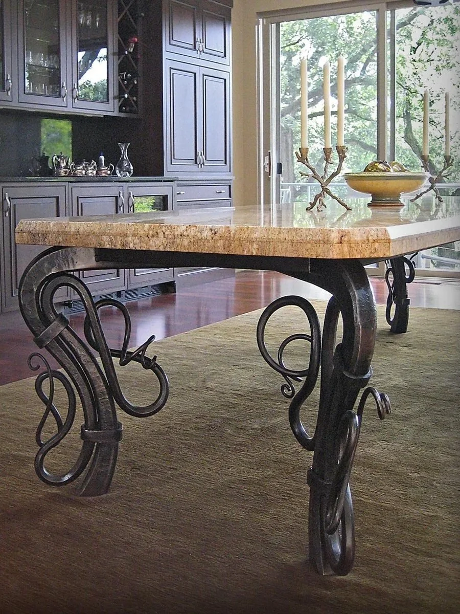 This custom coffee table features hand-forged iron legs with intricate scrollwork detailing, paired with a rich granite tabletop for a striking blend of artisan craftsmanship and natural elegance. Perfect for living rooms seeking a bold, one-of-a-kin