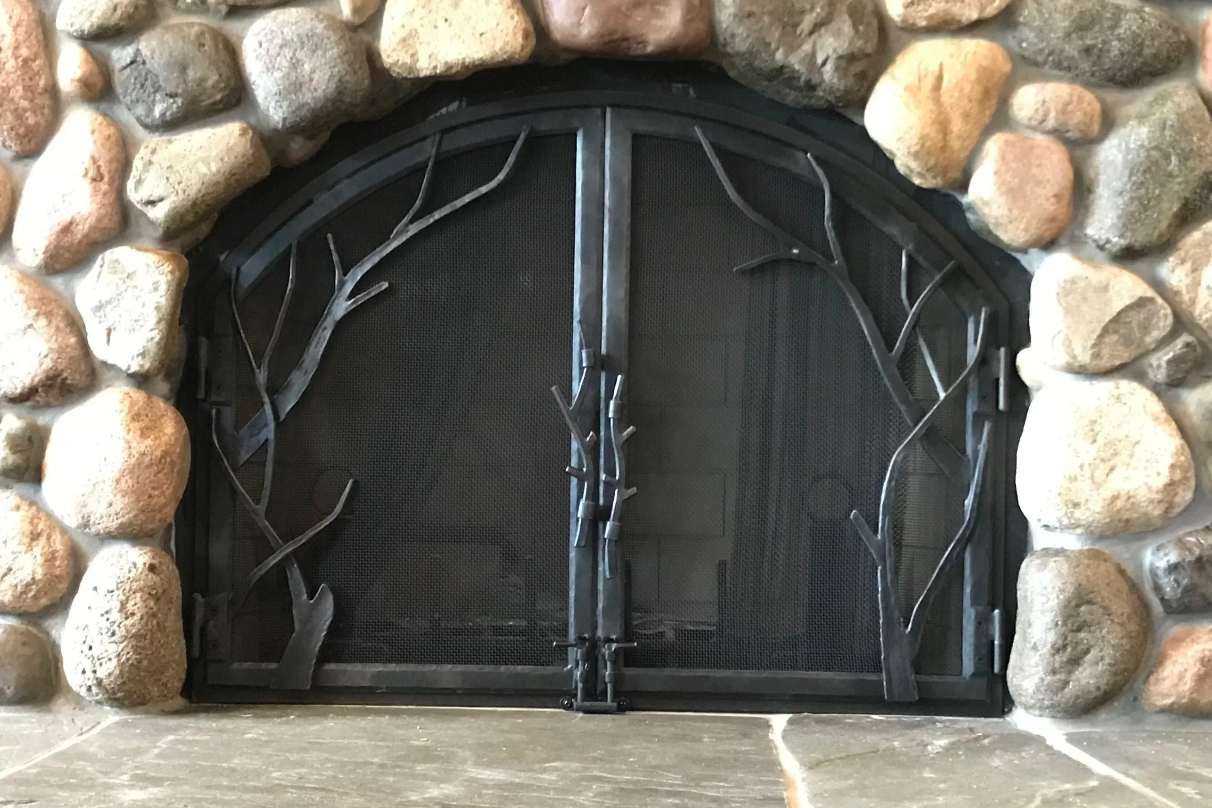 Custom Nature-Inspired Fireplace Screen – Handcrafted by Red Iron Studio, this custom forged steel fireplace screen features elegant tree branch detailing that brings the beauty of the outdoors into your home. Designed for both safety and style, each