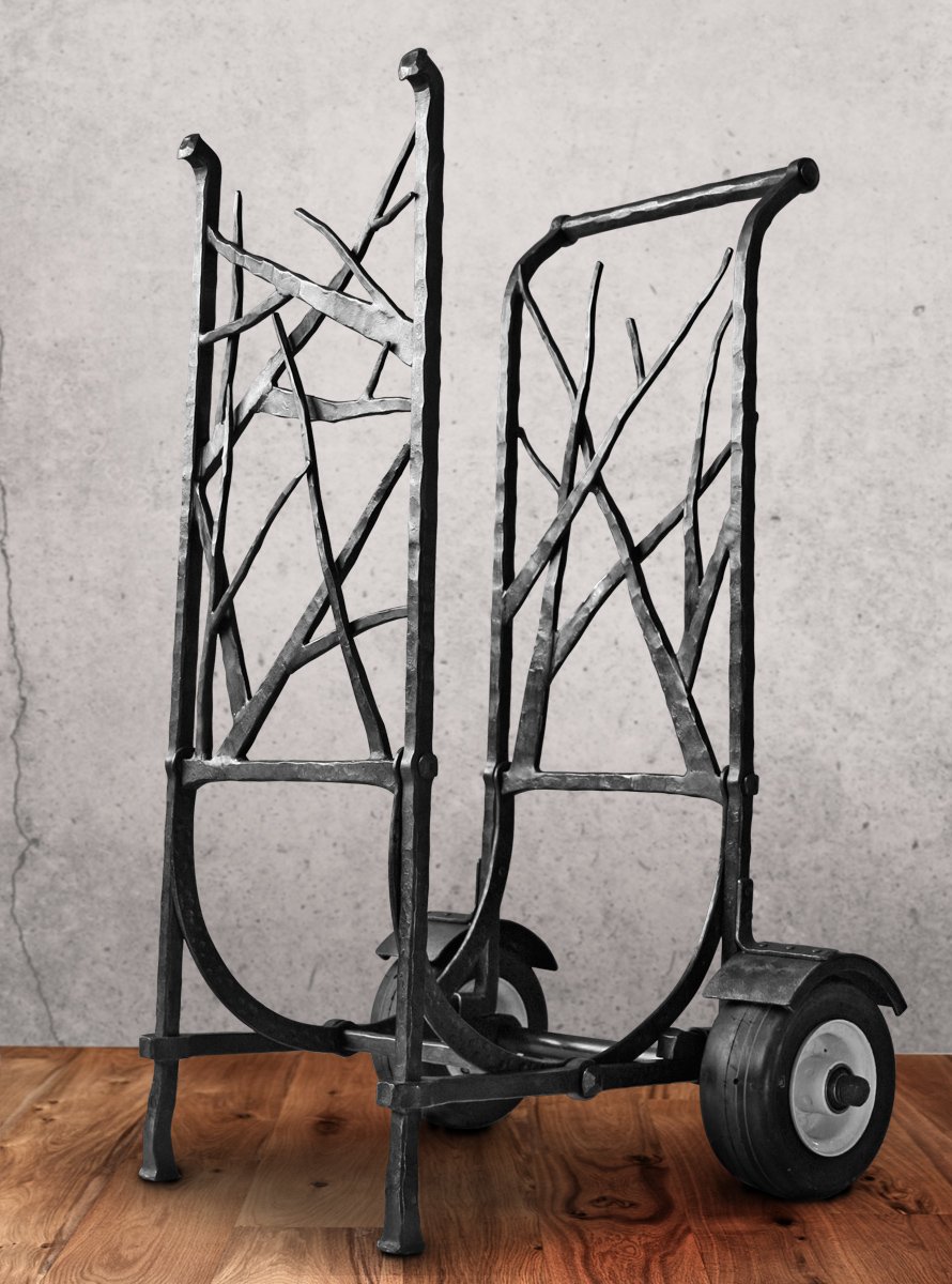 Custom hand-forged firewood cart by Red Iron Studio, featuring an organic branch-and-twig iron design with a rolling wheeled base for easy log transport. This handcrafted log cart combines rustic, nature-inspired blacksmithing with practical function