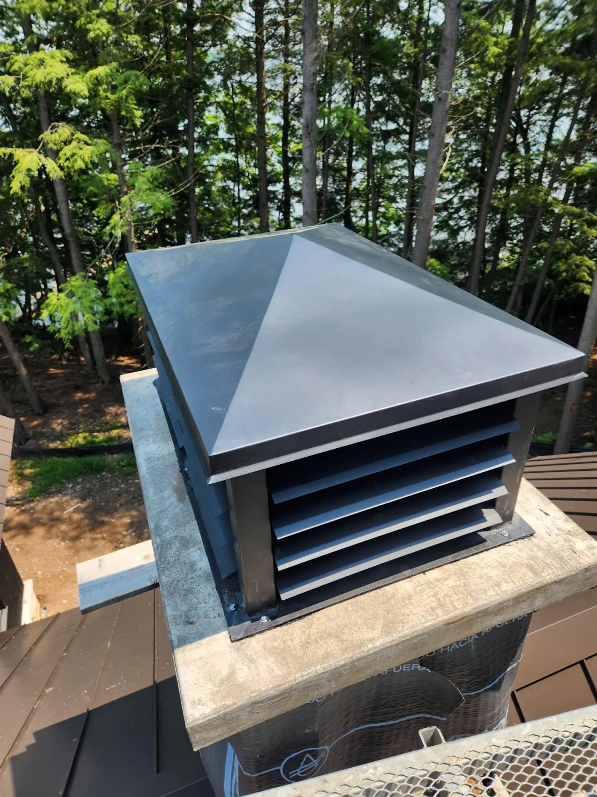 This custom-fabricated steel chimney cap features a sleek pyramid-style top and louvered side vents, combining weatherproof protection with a clean, modern architectural look. Built to fit a stone chimney, this durable custom chimney cover showcases 