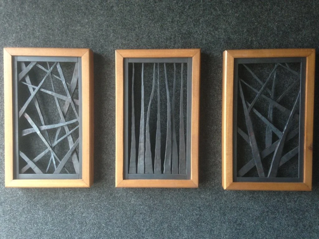 This three-panel framed metal wall art set features hand-forged steel elements in abstract linear and crosshatch patterns, offering a striking study in texture and movement for gallery walls or living spaces. A refined display of fine art metalwork, 