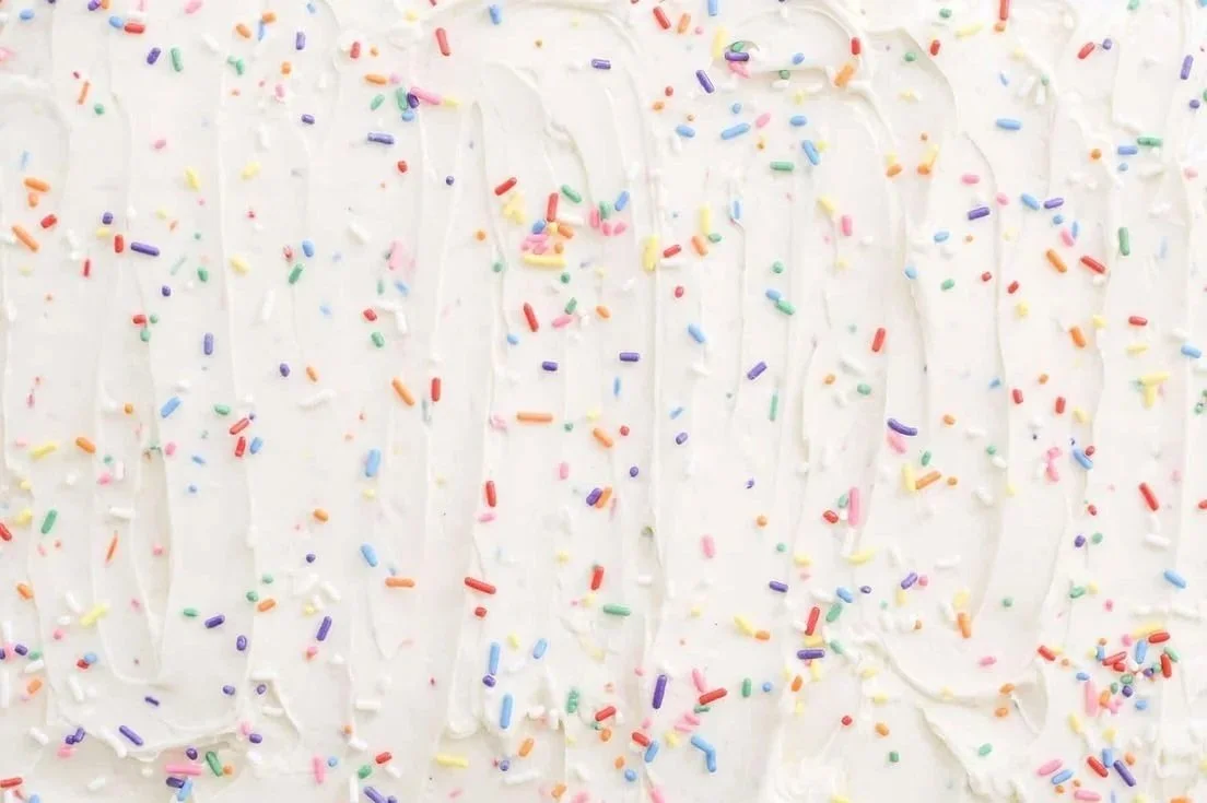 vanilla frosting with rainbow sprinkles