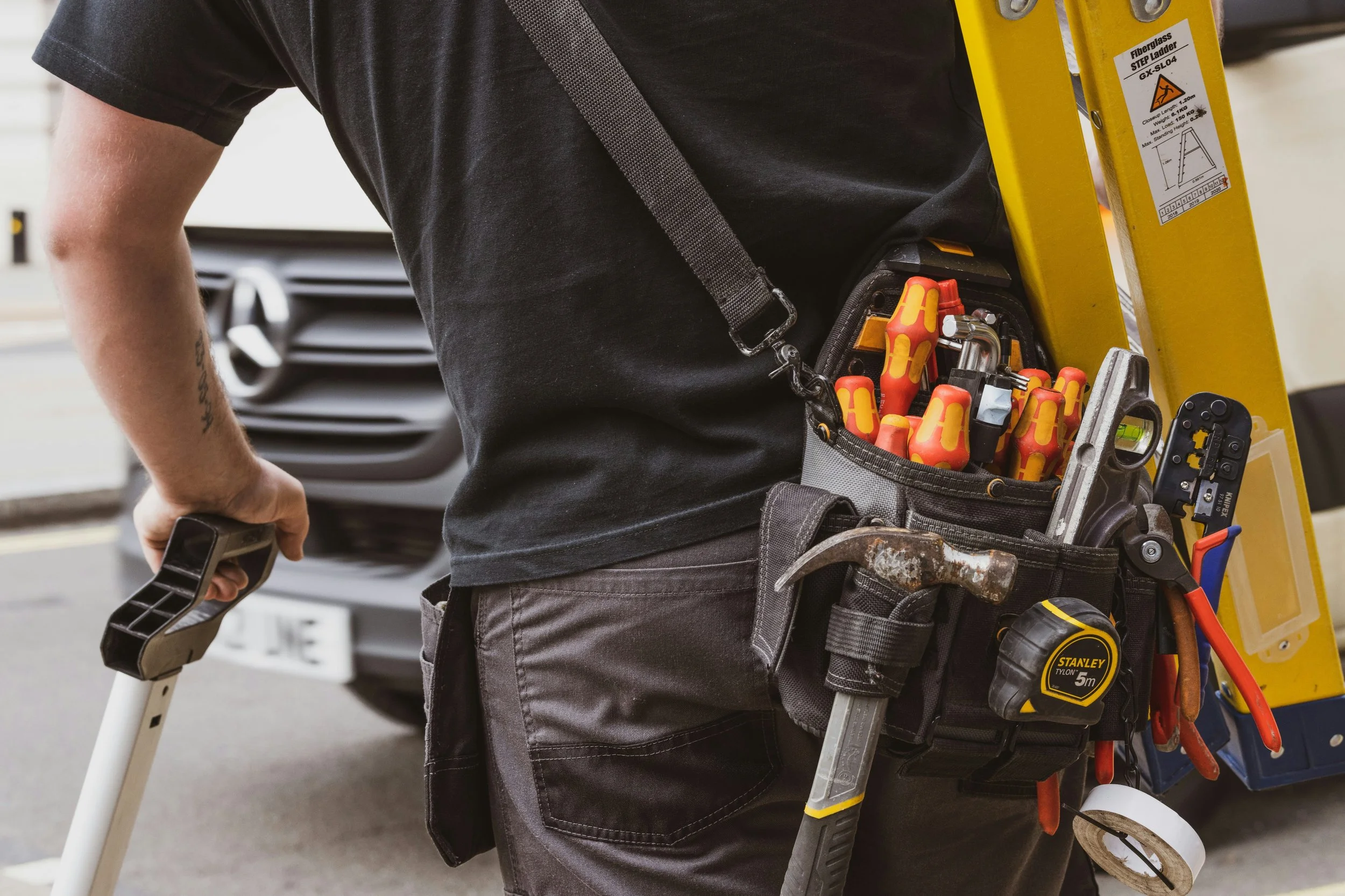 Electrician's tool belt with screwdrivers and measuring tape — the everyday gear Hoagie's Electric brings to every service call.