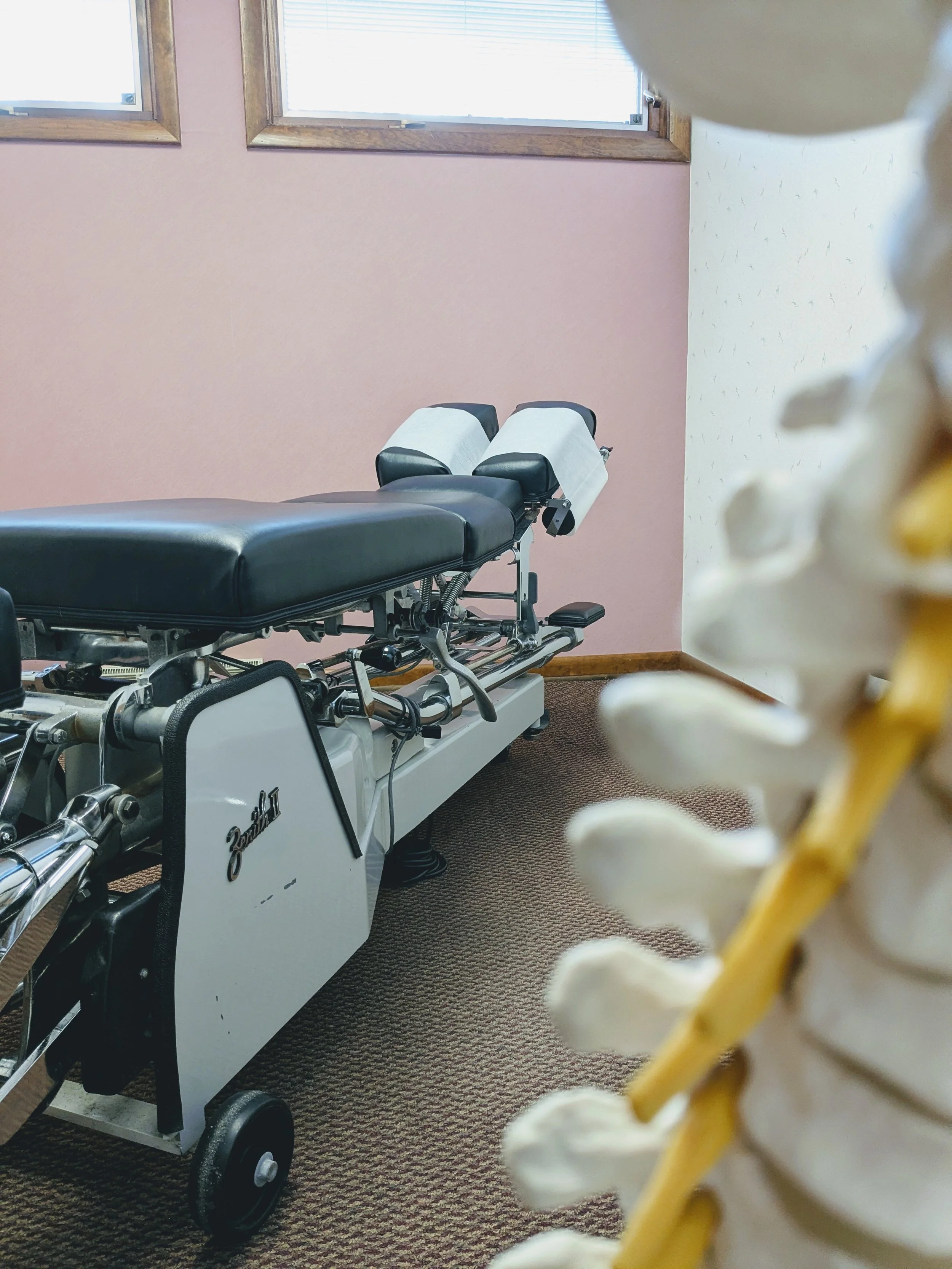 Chiropractic adjusting table located in room 3 with a display spine in the foreground
