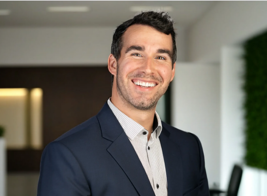 Professional headshot photo of Austin May in an office