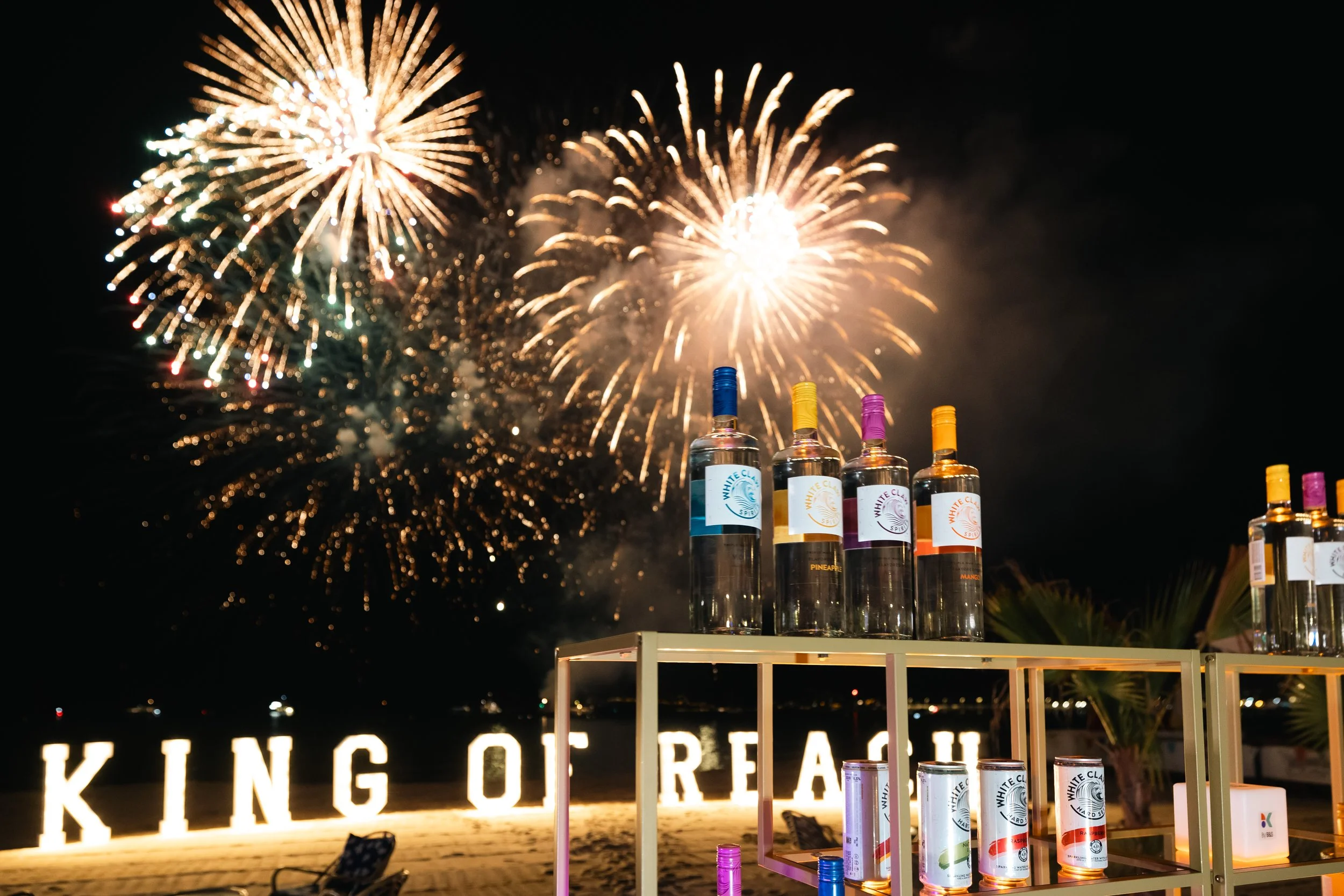 Soirée de marque sur une plage privée à avec bar personnalisé et feu d’artifice.
