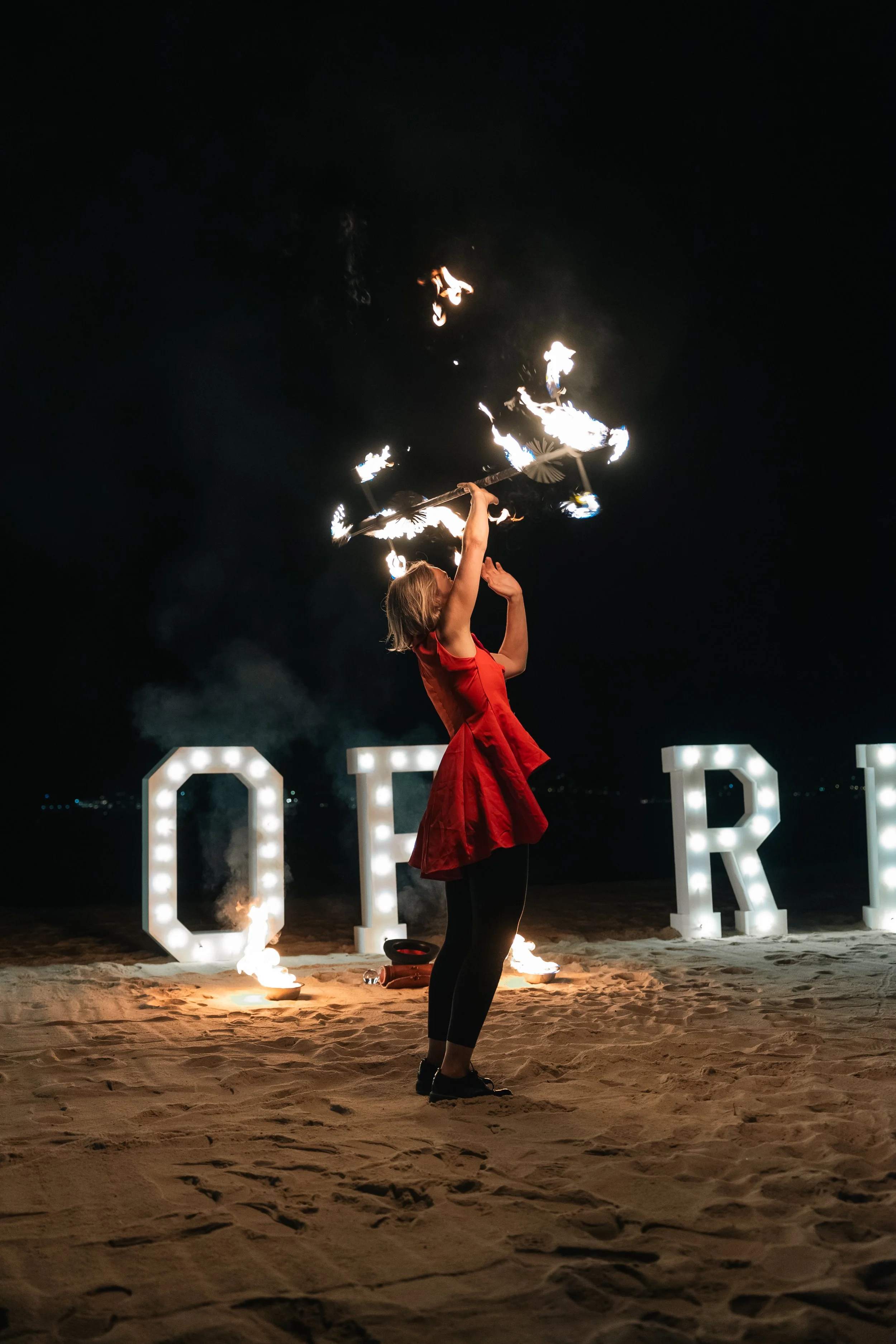 Animation et performance artistique de feu lors d’un événement privé sur une plage.
