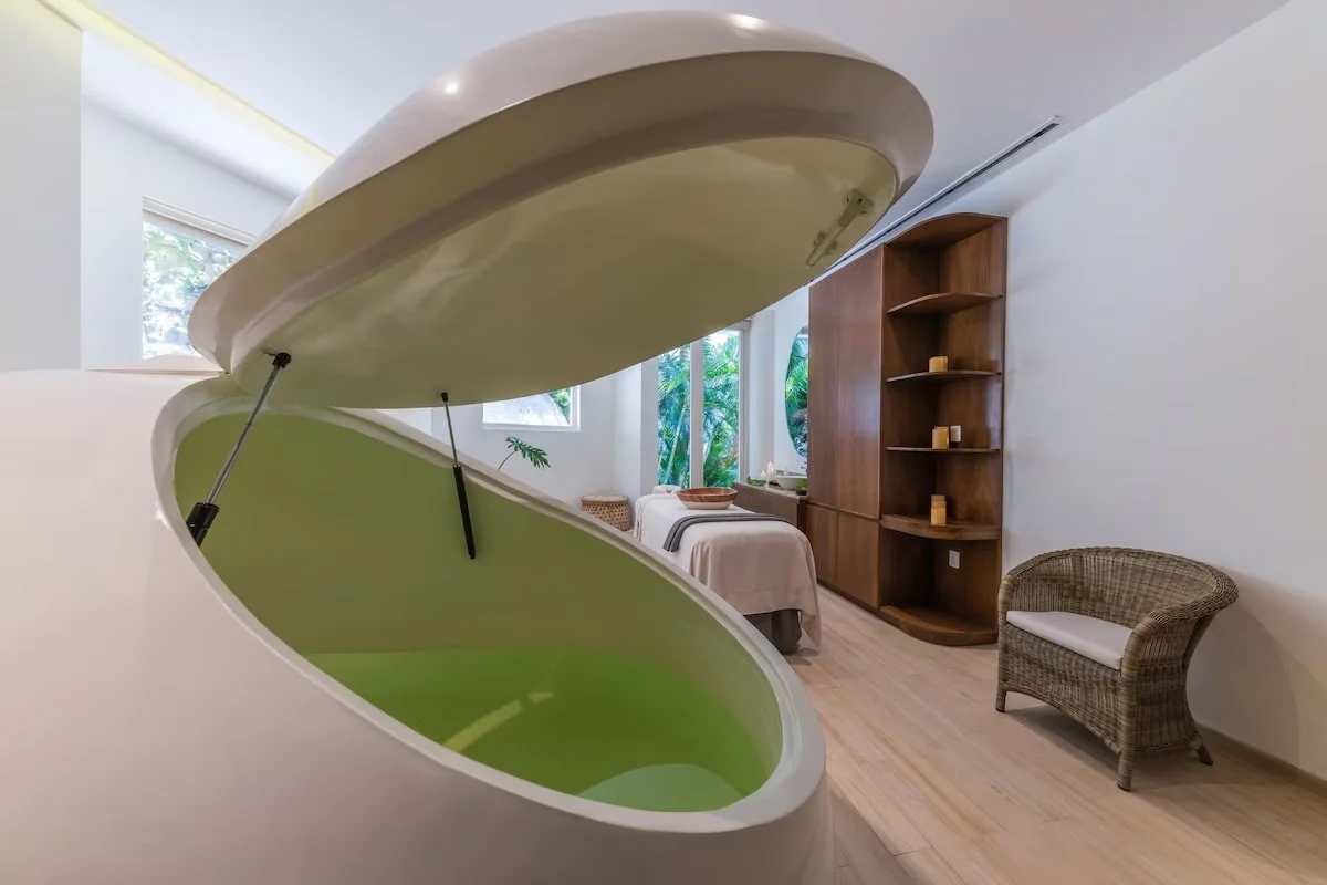 Open piano with green interior in a modern room with a bed, wicker chair, and wooden shelving.