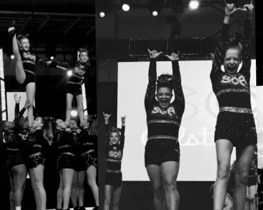 Cheerleaders performing stunts and cheers during a competition on stage, wearing matching black uniforms with the letters 'SCA'.
