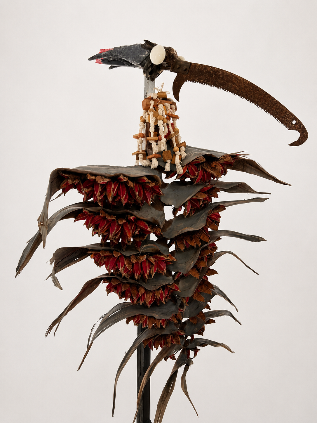 Lolis / 2017-2026 / Materials: Pruning saw, doorknobs, parrot toy, styrofoam, Lolis (African Grey) feathers, paint, Traveler's Palm tree material, wood pillar repurposed from decorative wedding arch 

