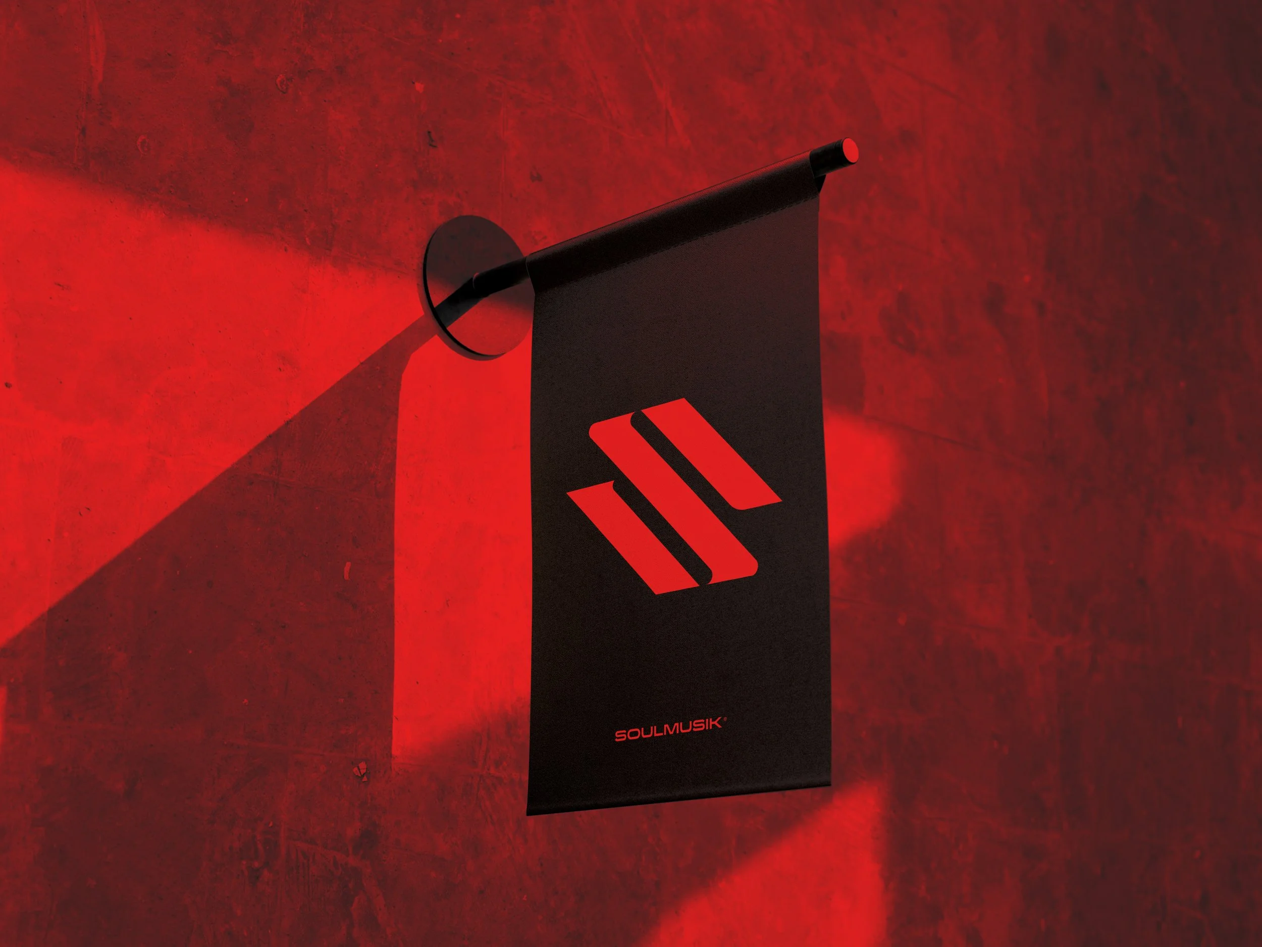 A black poster with red accents and the words 'SOULMUSIK' in small text at the bottom, mounted on a red wall, casting a shadow to the left.