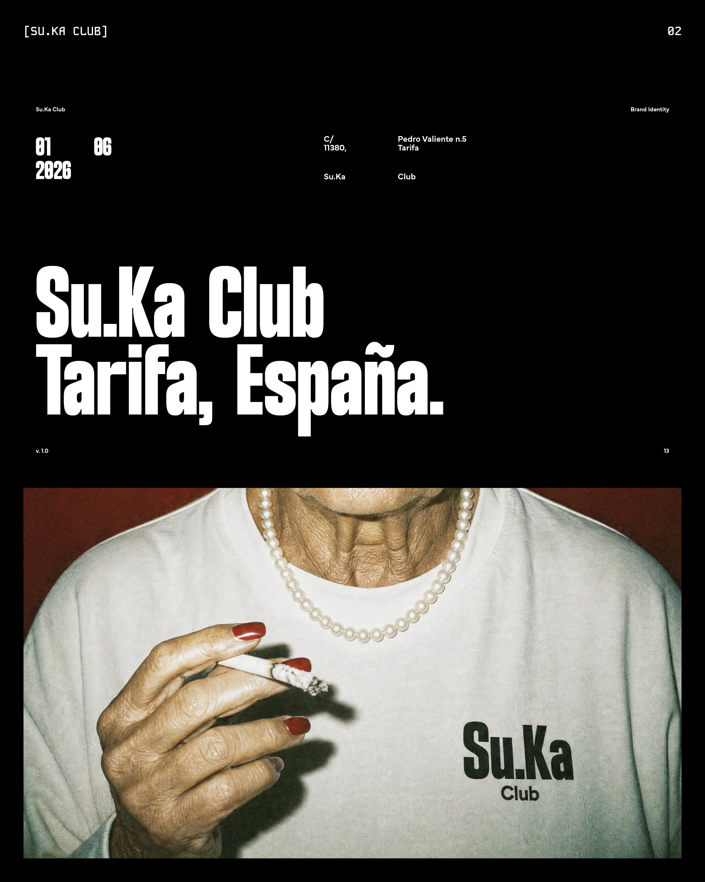 Close-up of an elderly woman holding a lit cigarette with red-painted fingernails. She is wearing a pearl necklace and a shirt that says 'Su.Ka Club' with the location 'Tarifa, España.'