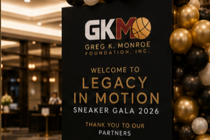 Event sign for the Greg K. Monroe Foundation's 'Legacy in Motion' Sneaker Gala 2026, with gold and black balloons in the background.