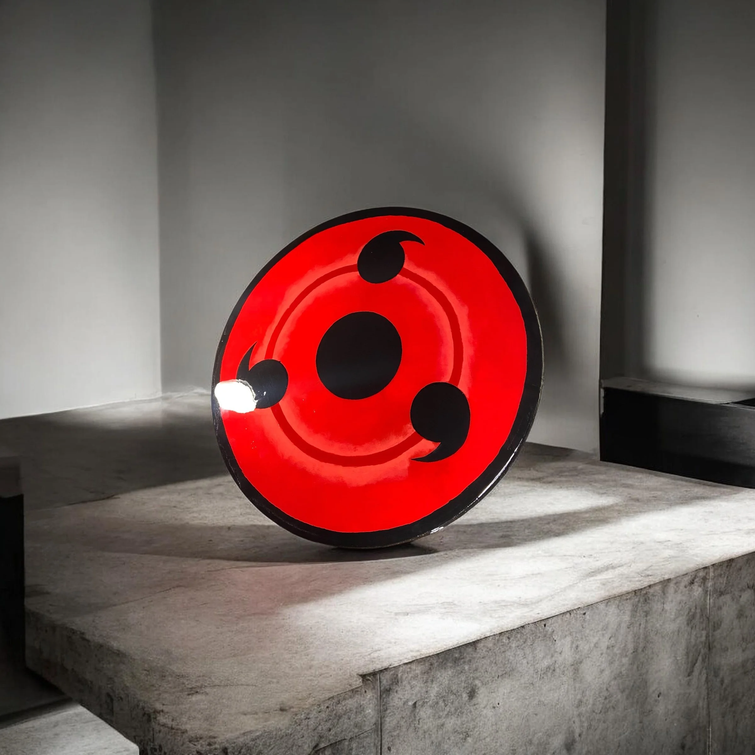 Red and black abstract art installation on a gray wall.