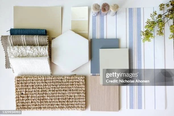 Various fabric, wallpaper, and paint samples arranged on a flat surface for home interior design.
