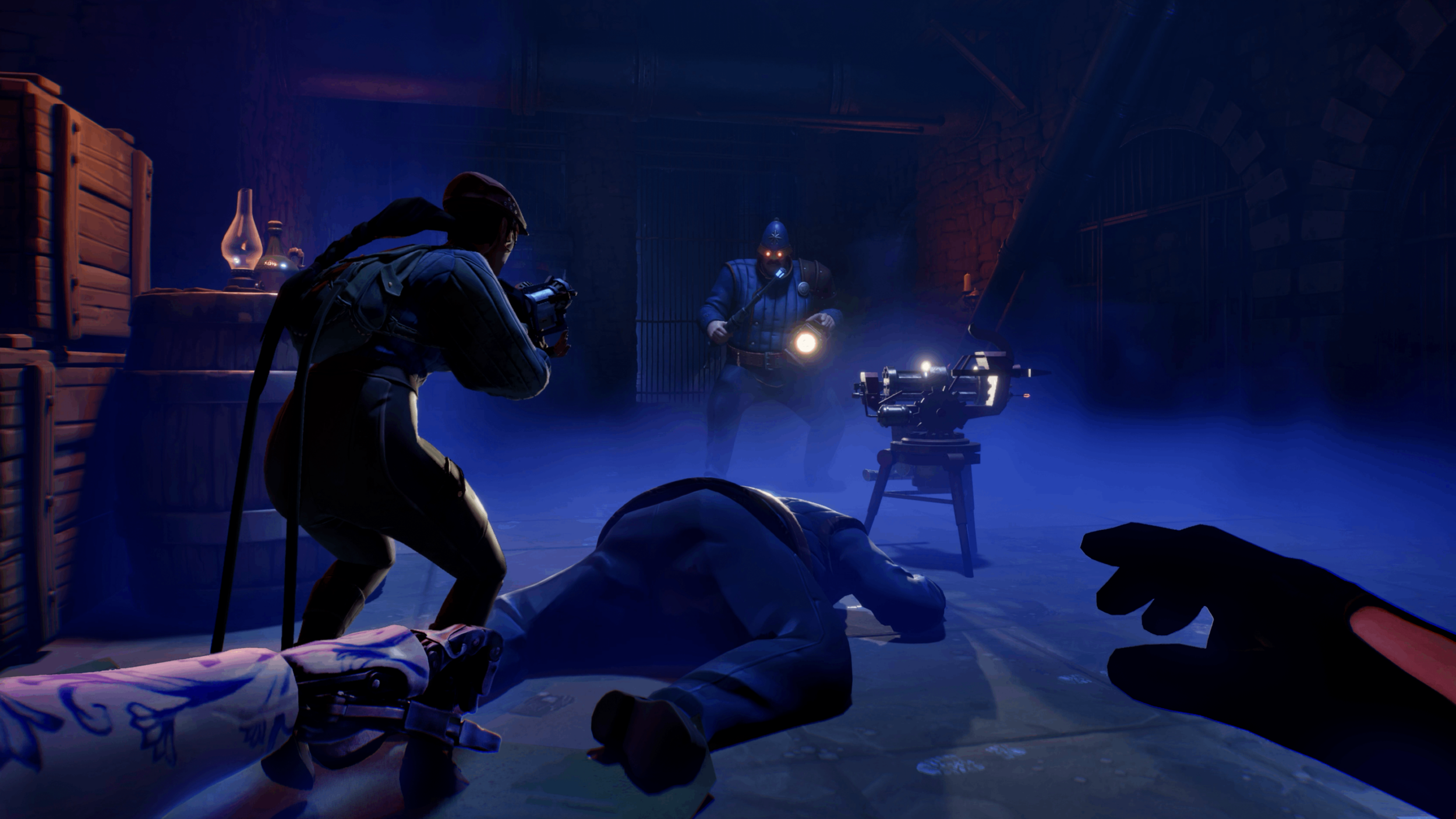 A scene depicting a theatrical or film production set in a dark, dungeon-like environment with brick walls and bars. There are three people, two are dressed as police officers or security personnel, one holding a flashlight, and the other standing behind the camera. The third person is lying on the ground, and a camera is set up in front of them, capturing the scene. The scene is illuminated with blue light.