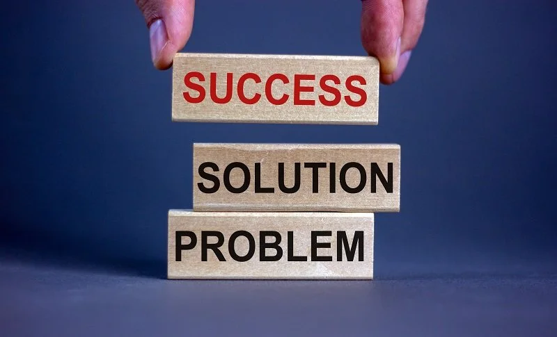 FIngers stacking word blocks problem, solution, success on blue background.