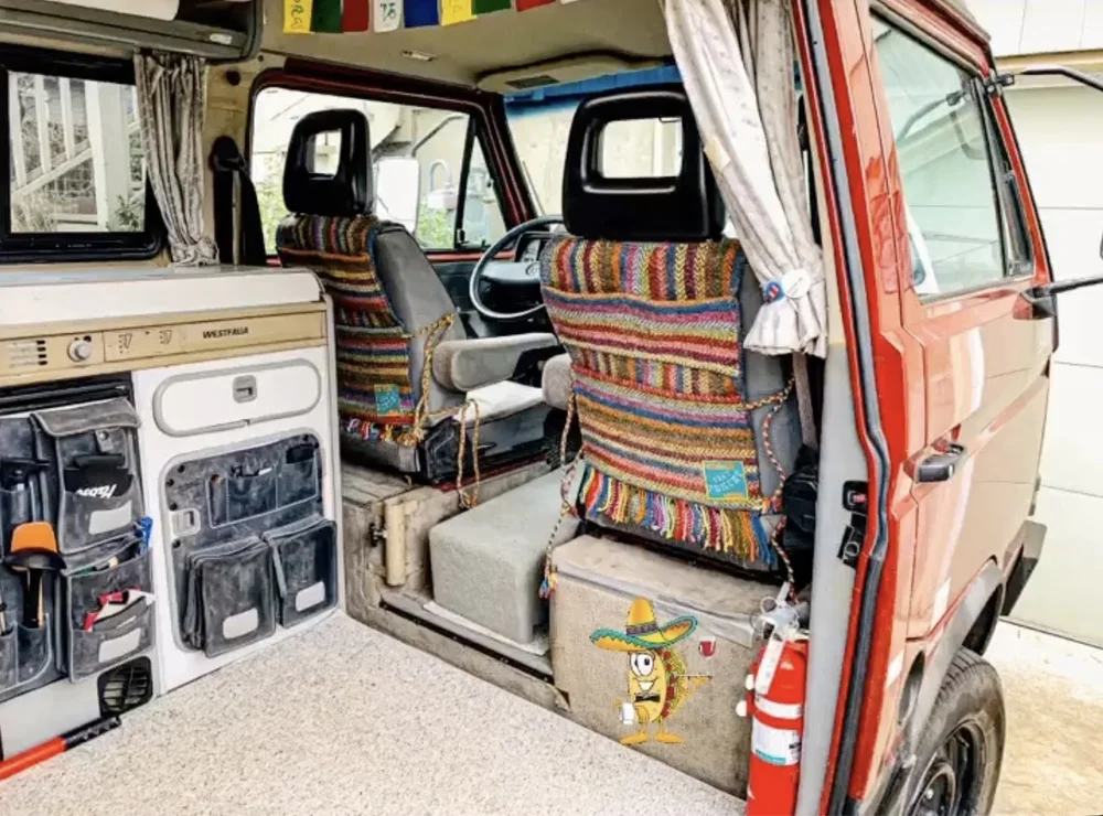 Colorful woven Seat Poncho organizer fitted to the back of a front seat in a camper van