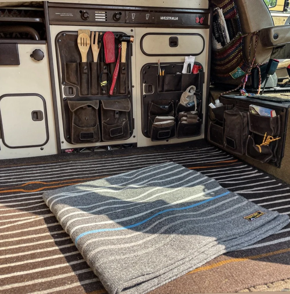 Striped handwoven Oaxacan rug covering the floor beside a Vanagon Westfalia kitchen