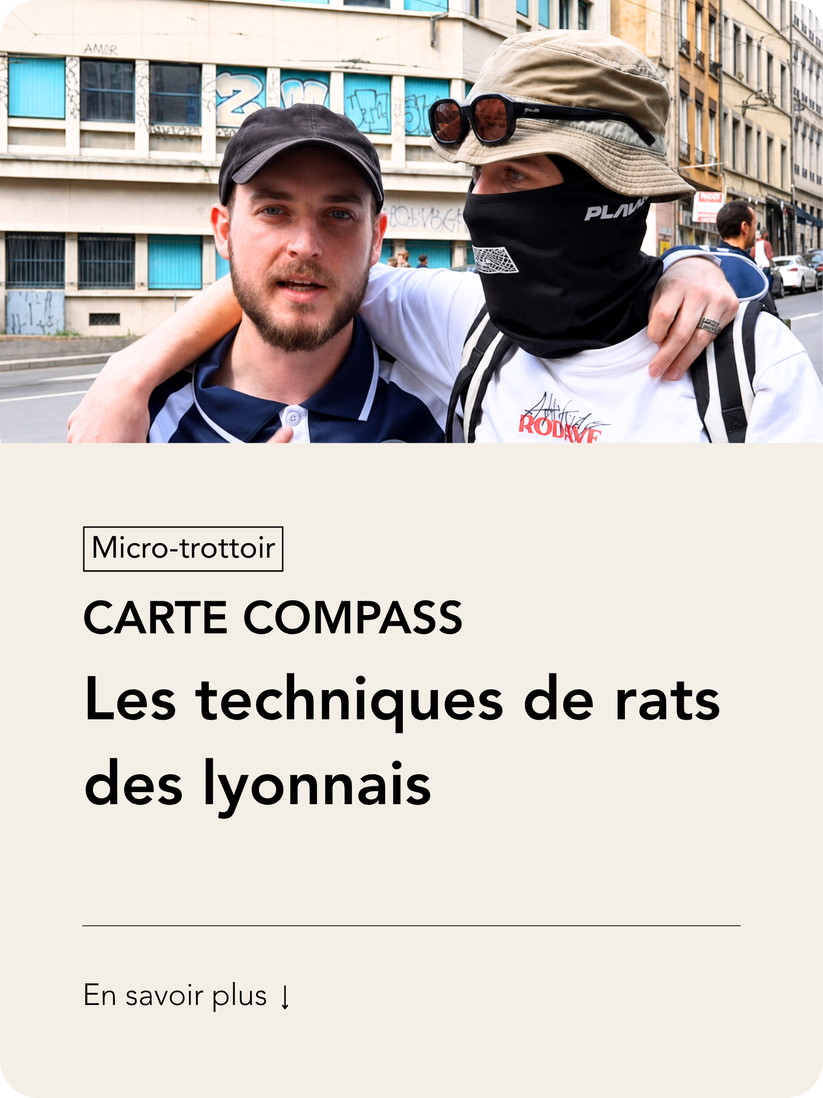Deux jeunes hommes posent ensemble dans la rue, l'un avec un bonnet noir et une barbe, l'autre portant un chapeau beige, un masque noir couvrant la moitié de son visage, et des lunettes sur le chapeau. Au fond, un bâtiment avec des graffitis.