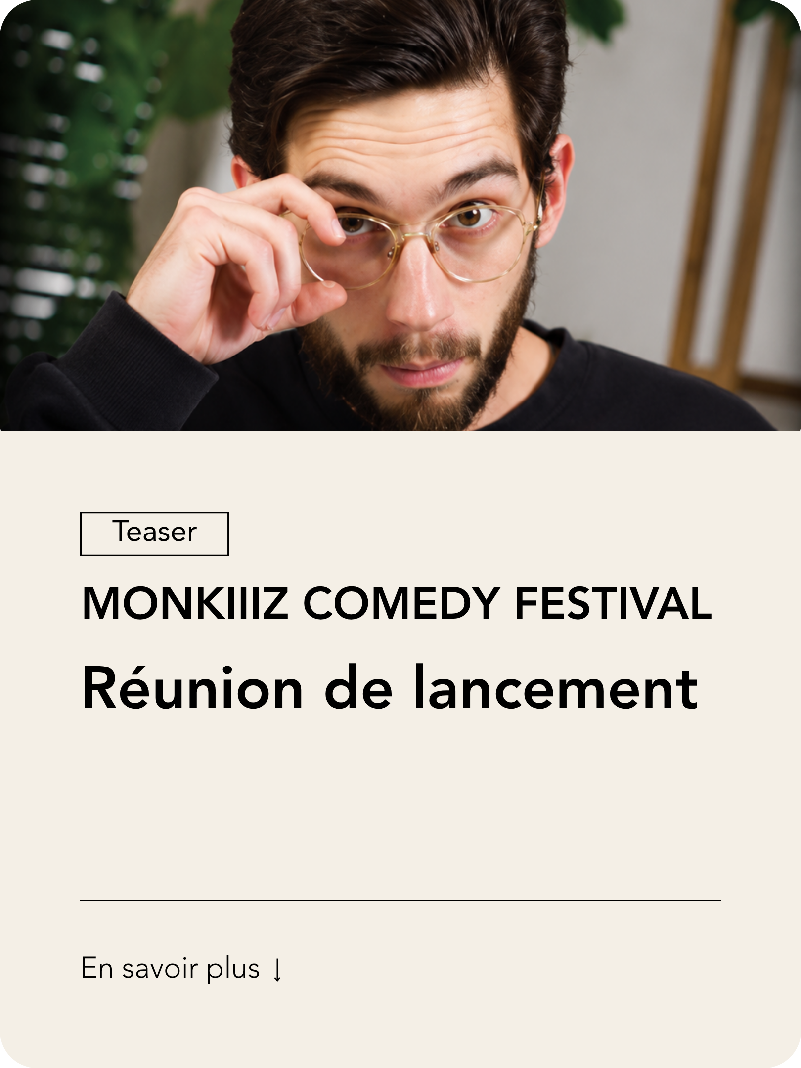 Un homme avec des lunettes, portant un sweat noir, regarde directement la caméra avec un regard curieux.
