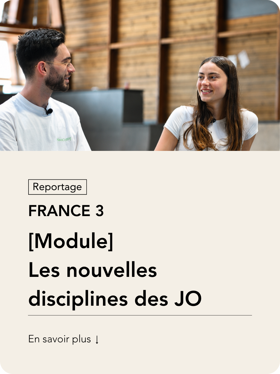 Une jeune femme et un jeune homme discutent dans un intérieur avec des murs en bois, souriants et engagés dans la conversation.