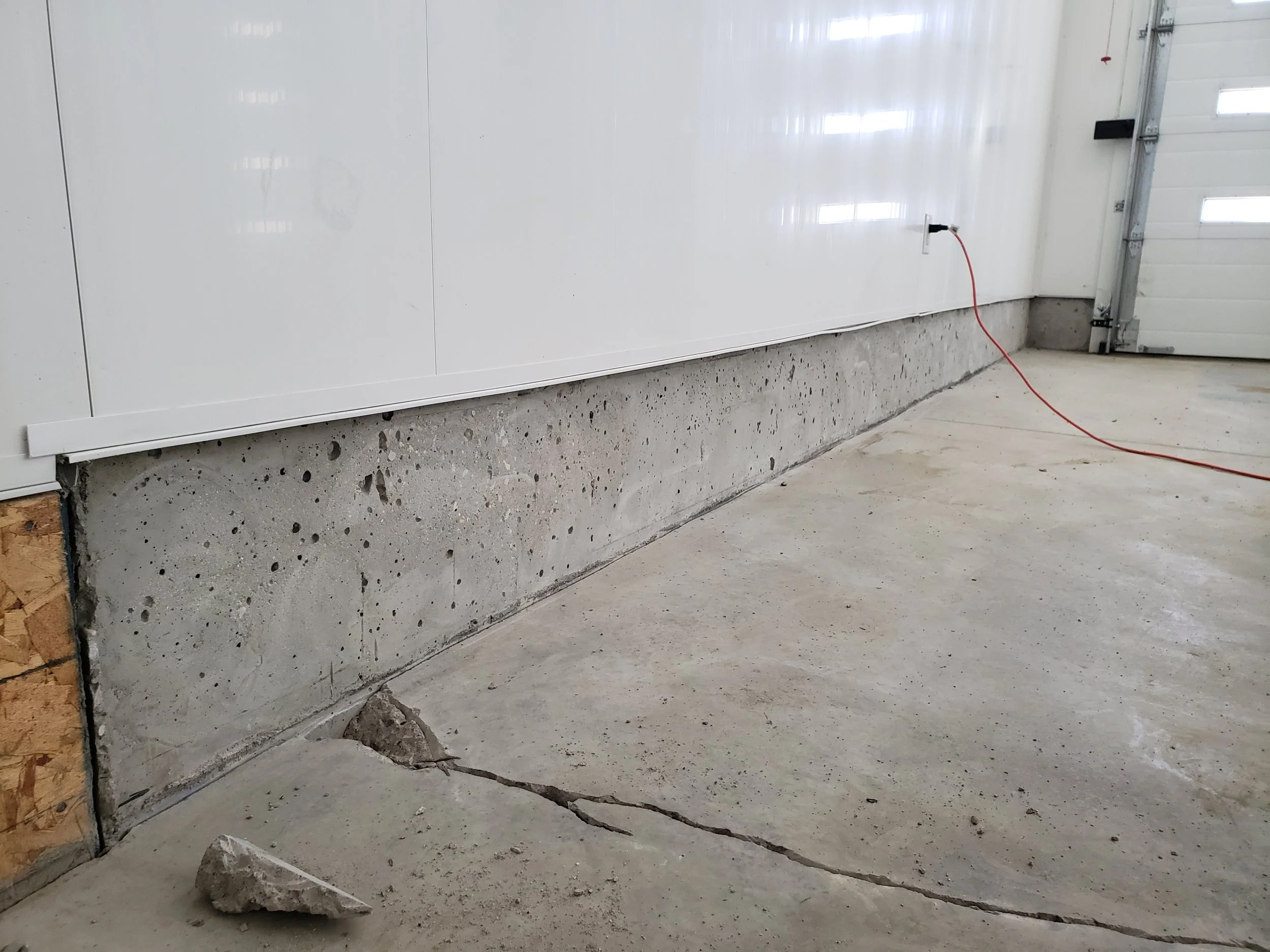 Unfinished damaged, cracked garage floor. 