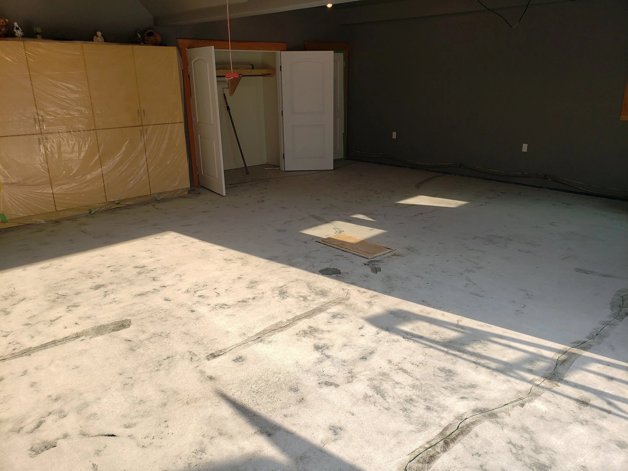 Garage floor concrete repaired and grinded, prepared for coating.