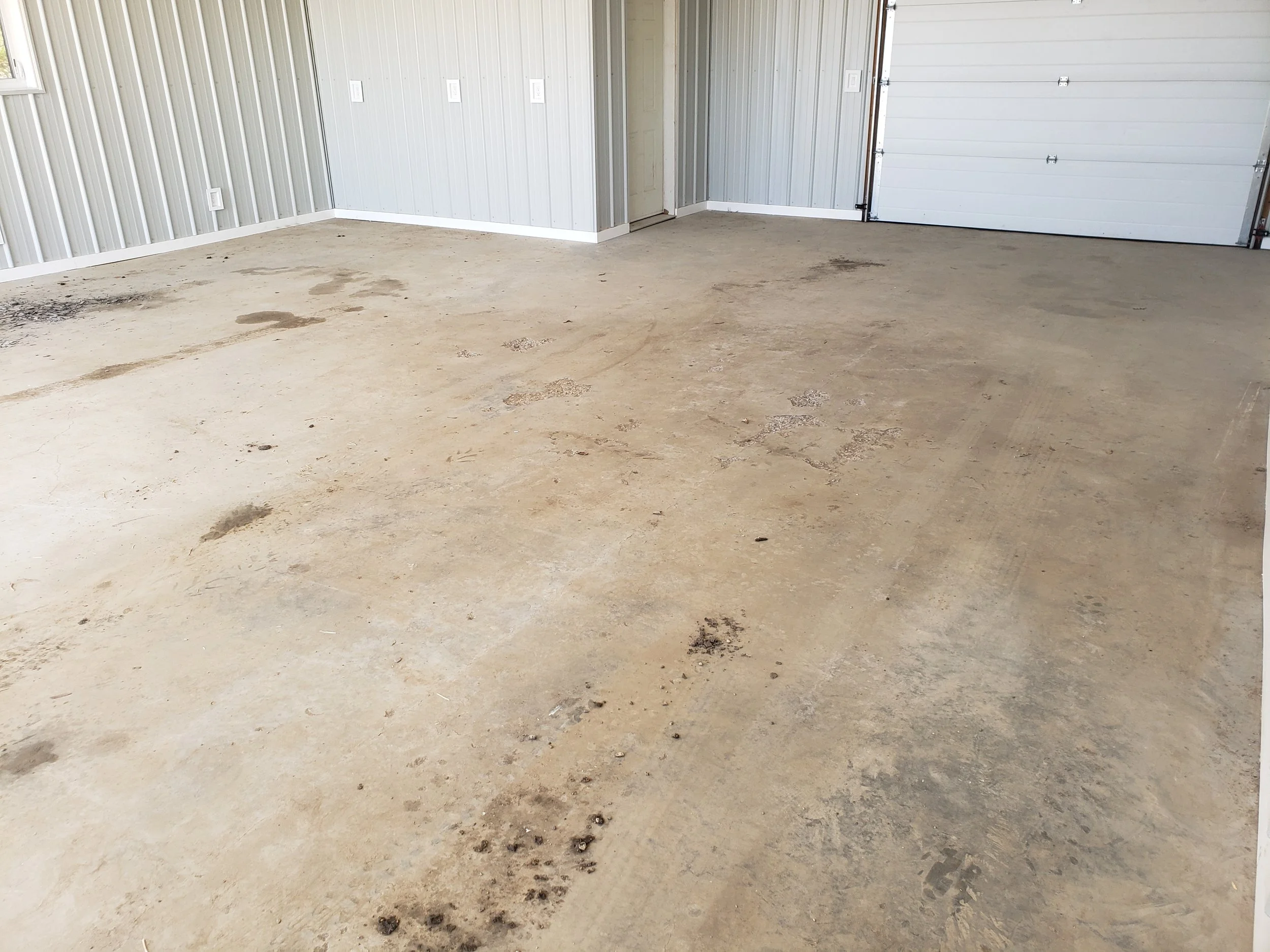 Garage floor with pitting and spalling, before coating. 