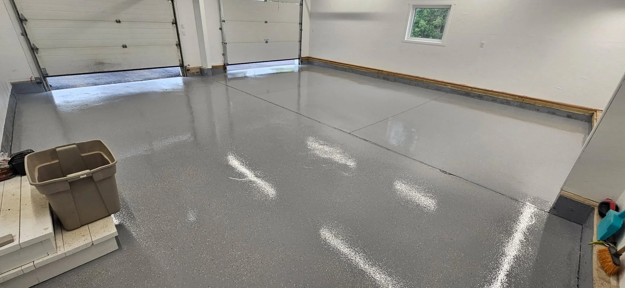 Partial flake broadcast polyaspartic coated garage floor.