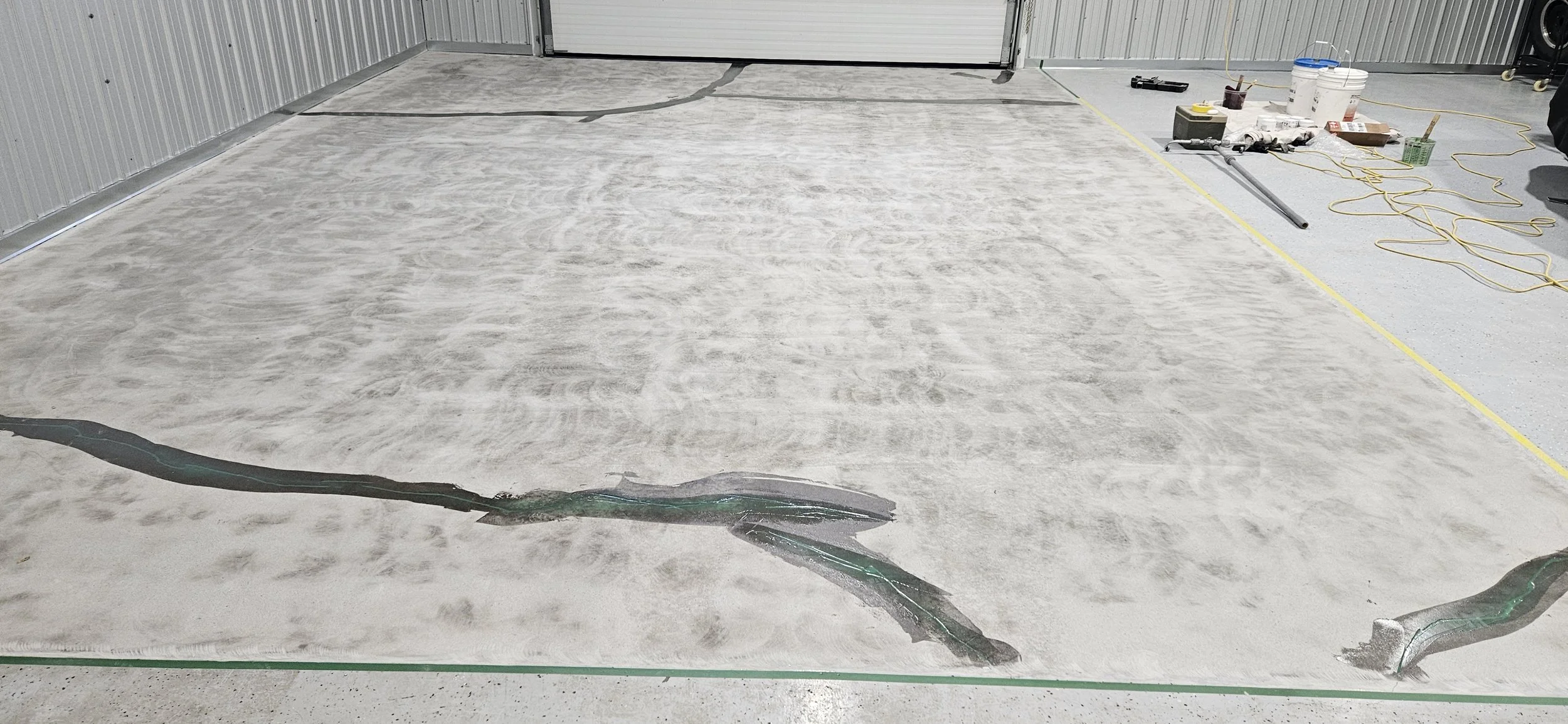 BEFORE - Bare concrete grinded and repaired. Sectioned off areas