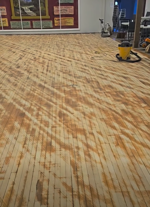 Sanding in progress for refinishing hardwood flooring, town hall.